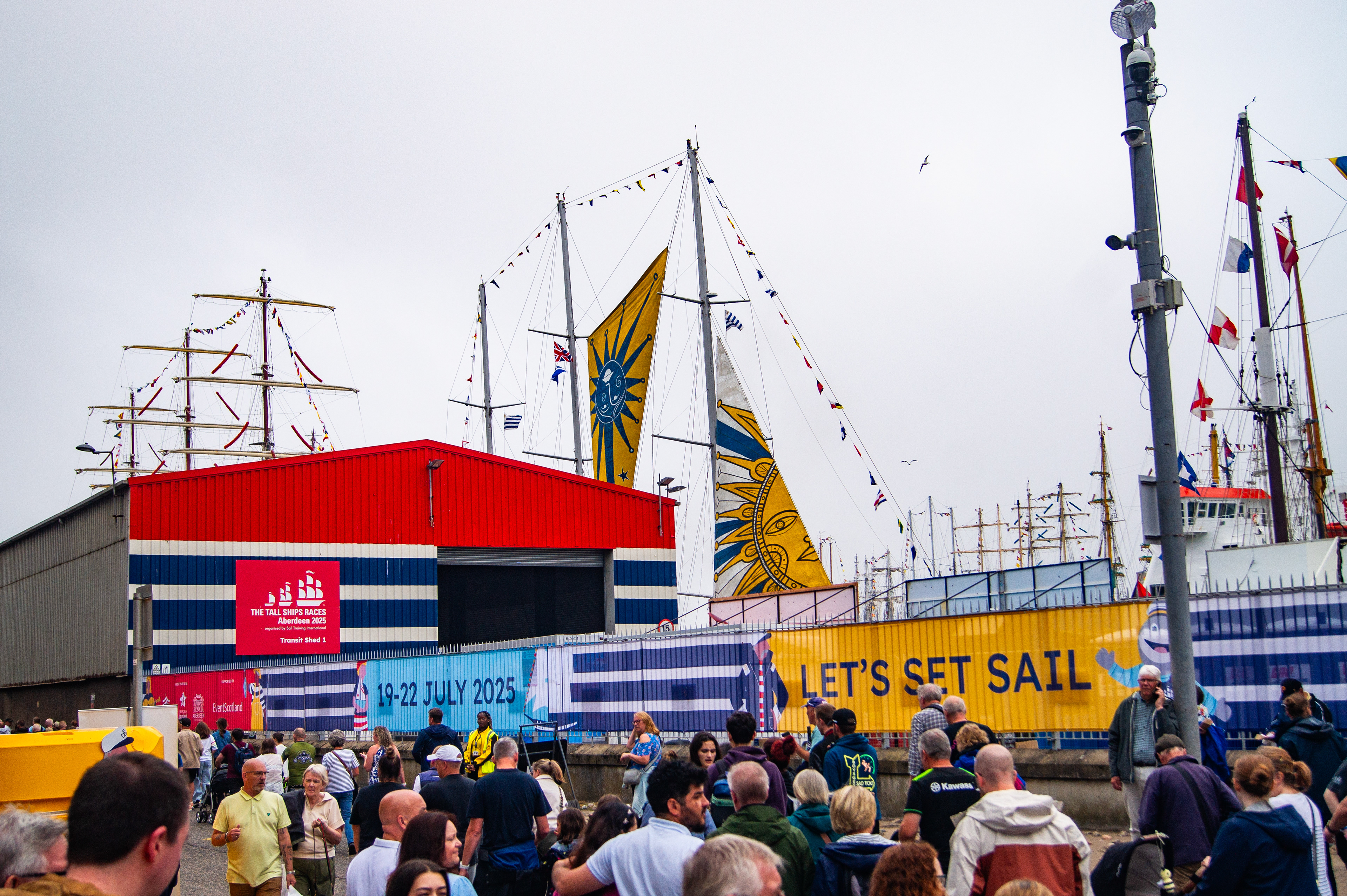 Festival-wide branding for the Tall Ships Race Aberdeen 2025 with venue dressing, stage graphics, bunting, and city centre applications.