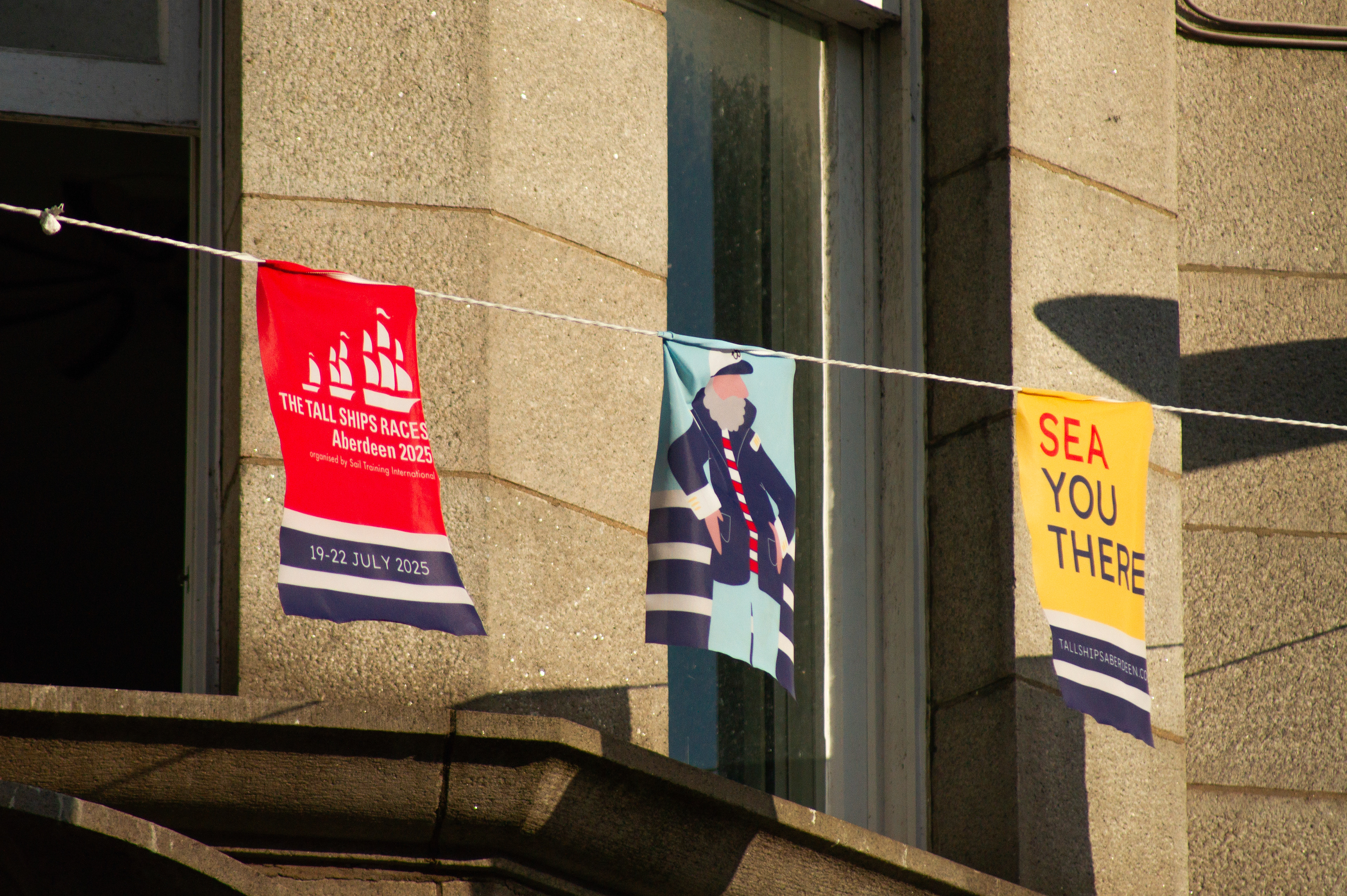 Festival-wide branding for the Tall Ships Race Aberdeen 2025 with venue dressing, stage graphics, bunting, and city centre applications.