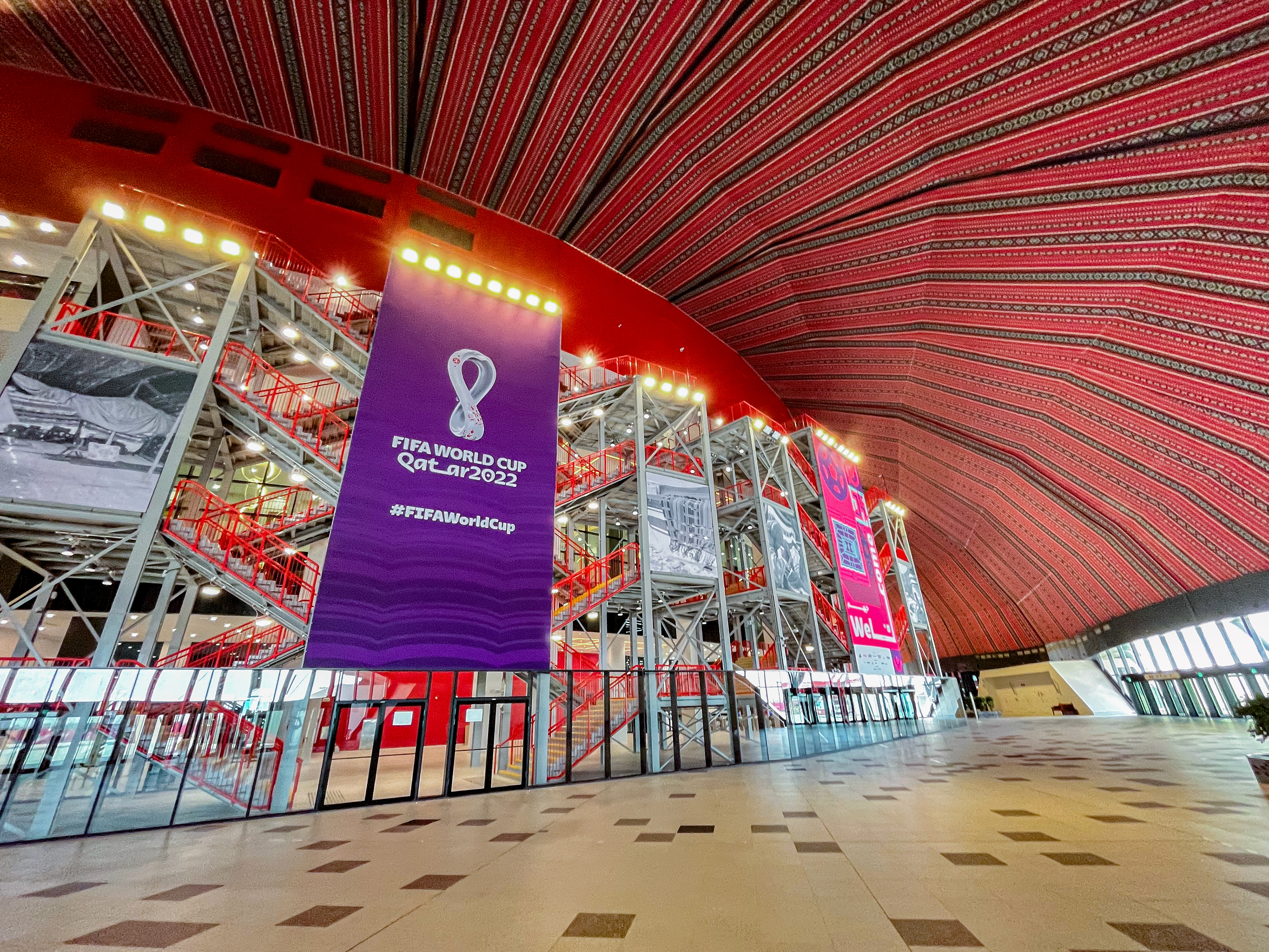 A overview of the spectator concourse at Al Bay Stadium with large sale branding applications know as Supersites, at FIFA World Cup Qatar 2022