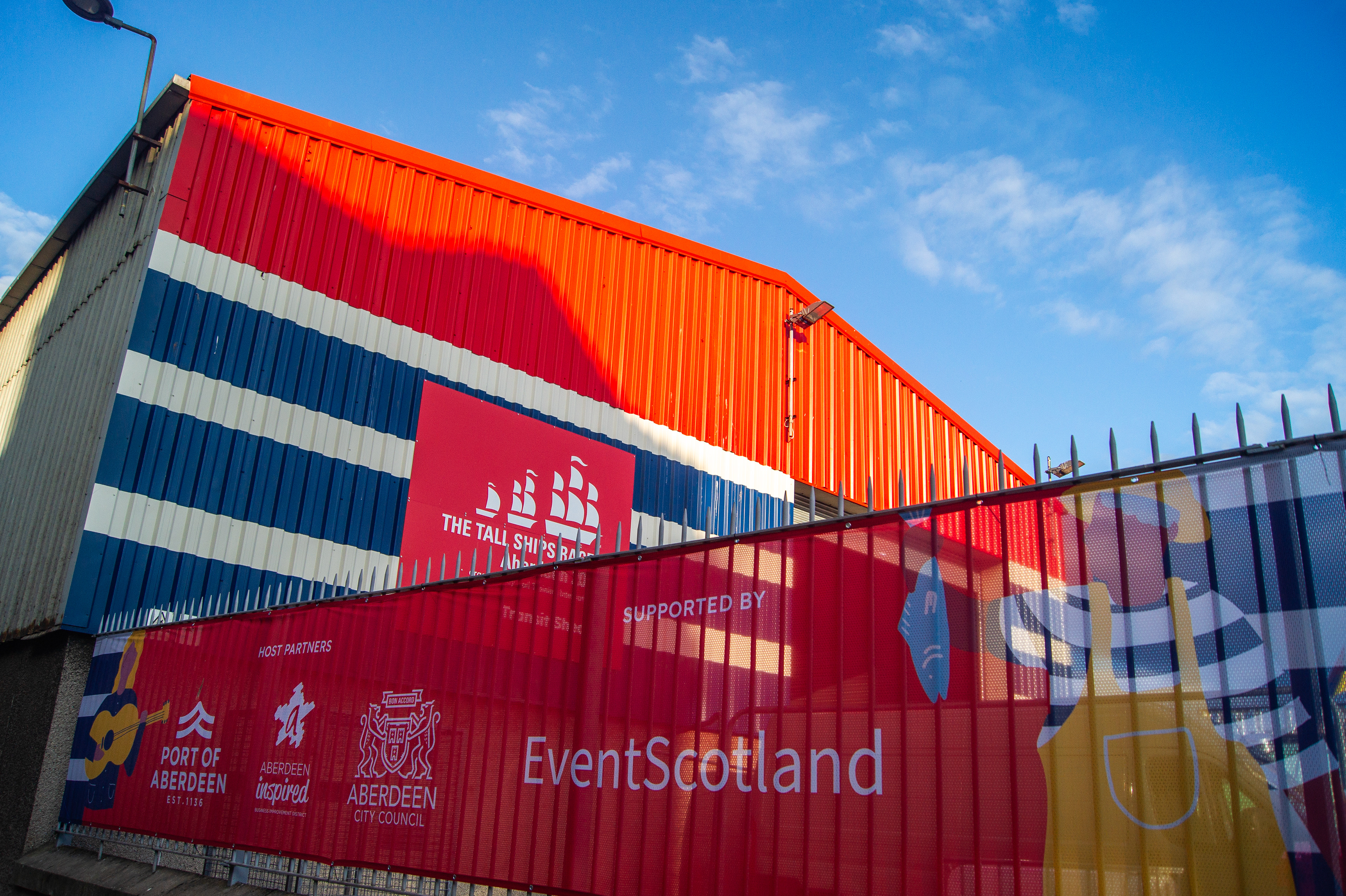Bespoke event branding projects for Tall Ships Aberdeen 2025 including painted sheds, branded maritime buoys, and entrance gantry installations