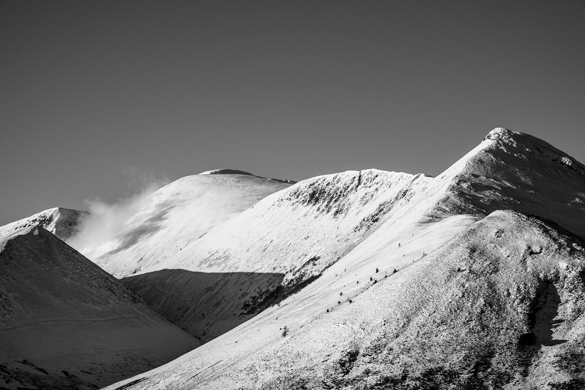 Black-and-white landscape shot of a snow capped Causey Pike and windswept ridge,.