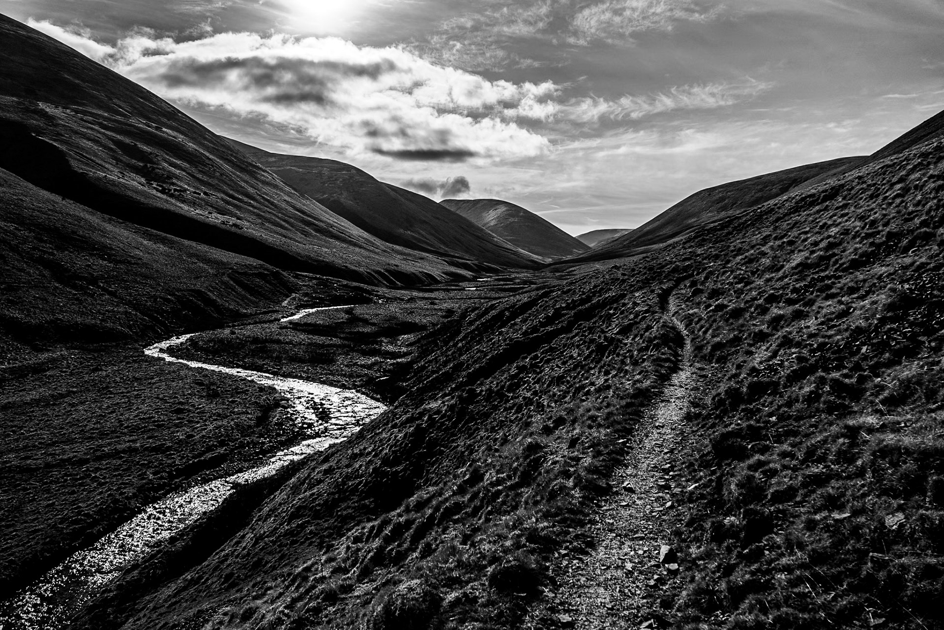 Strong sunlight picks out a meandering Bowderdale Beck in the Howgill Fells, Cumbria. 