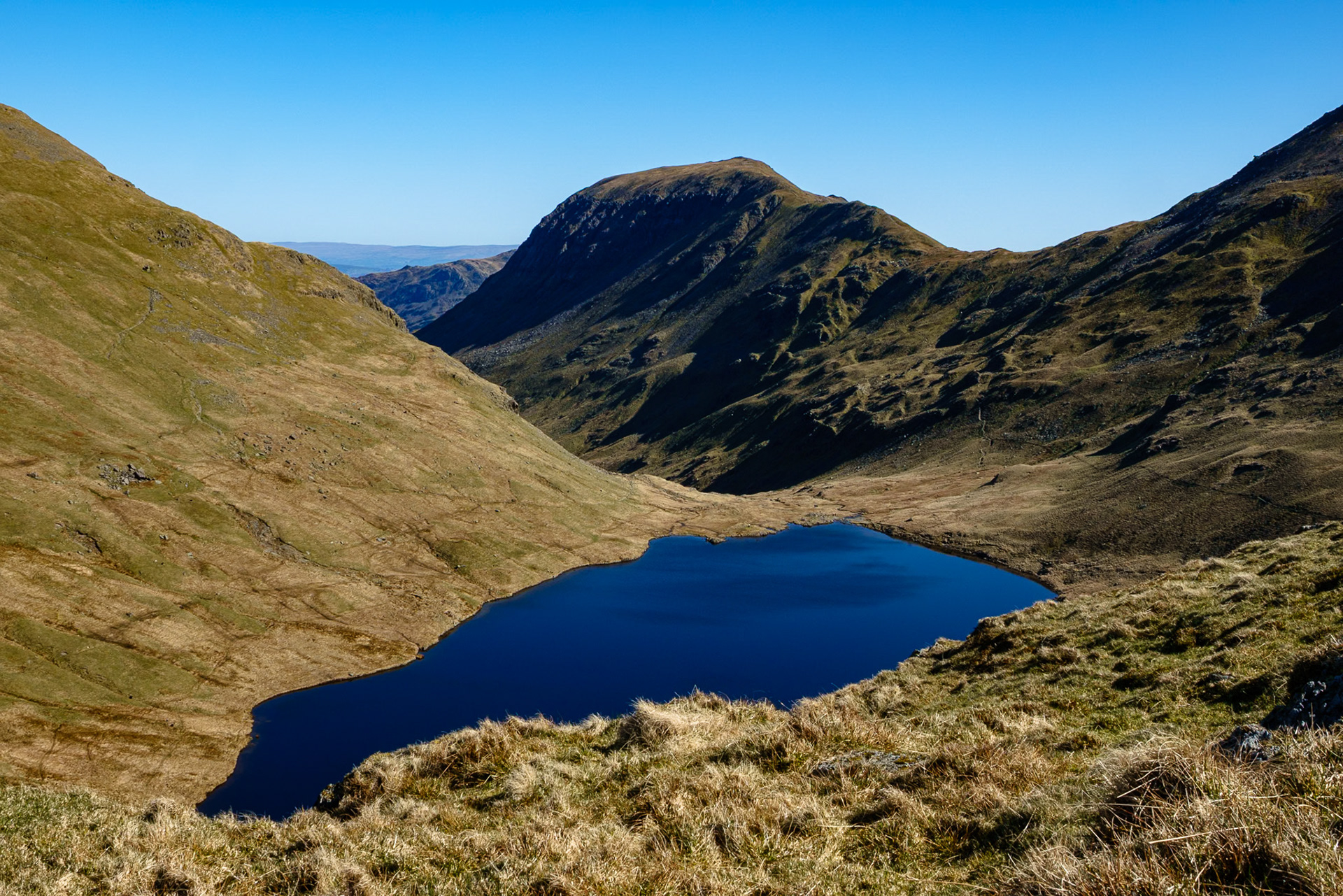 A deep blue Grisdale Tarn surrounded nestled under Dollywaggon Pike and St Sundays Crag.