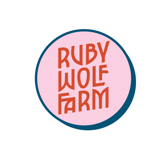 Logo for social media use that reads as Ruby Wolf Farm in red text on a pink circle background, it has a fairytale-like look