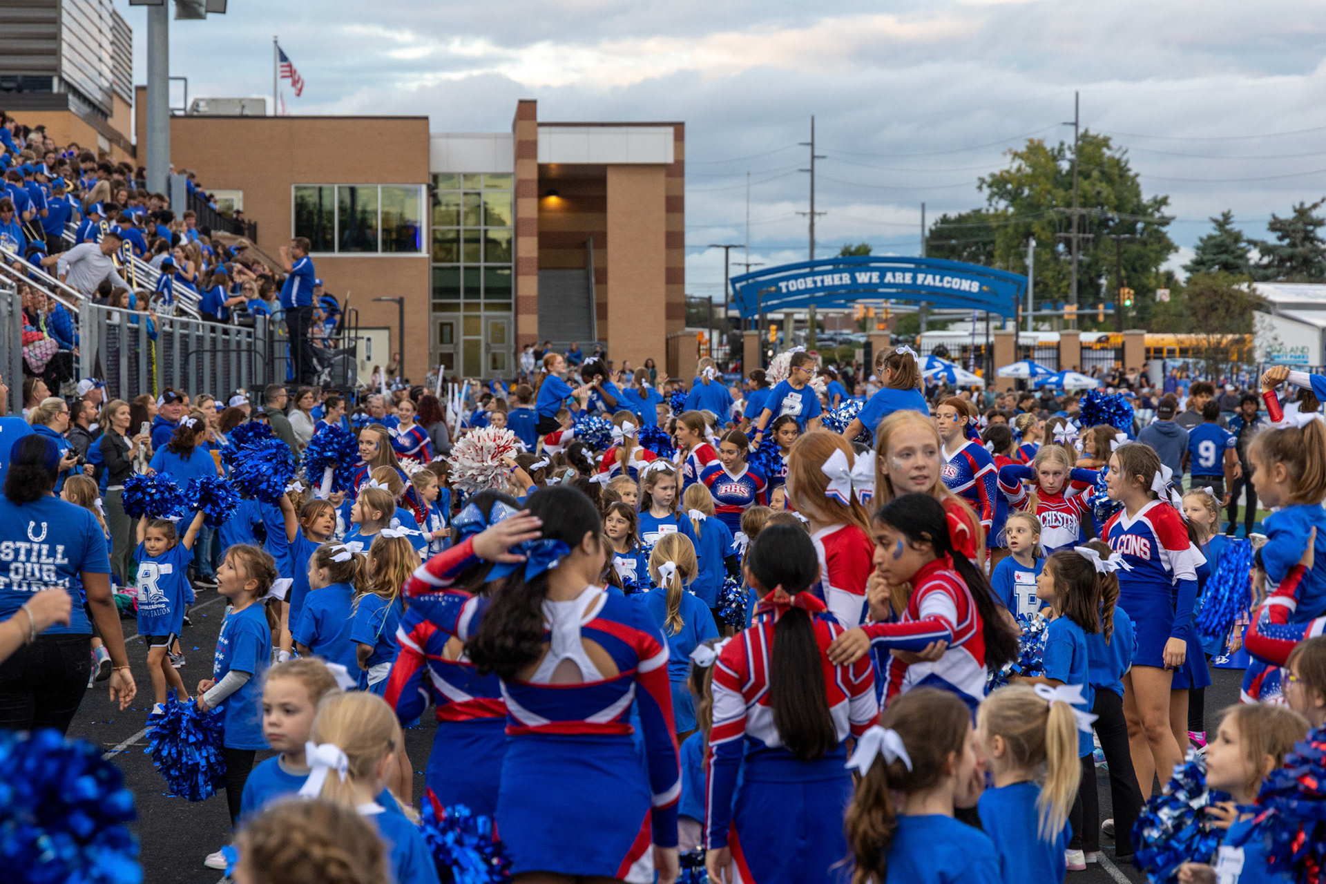 A sea of blue. (The picture is very scenery overloading and thats on purpose because I wanted to emphasize the younger kids and the cheerleaders with the sign in the back of "Together we are falcons", thought itd be cool to bring some meaning to the photo)) 