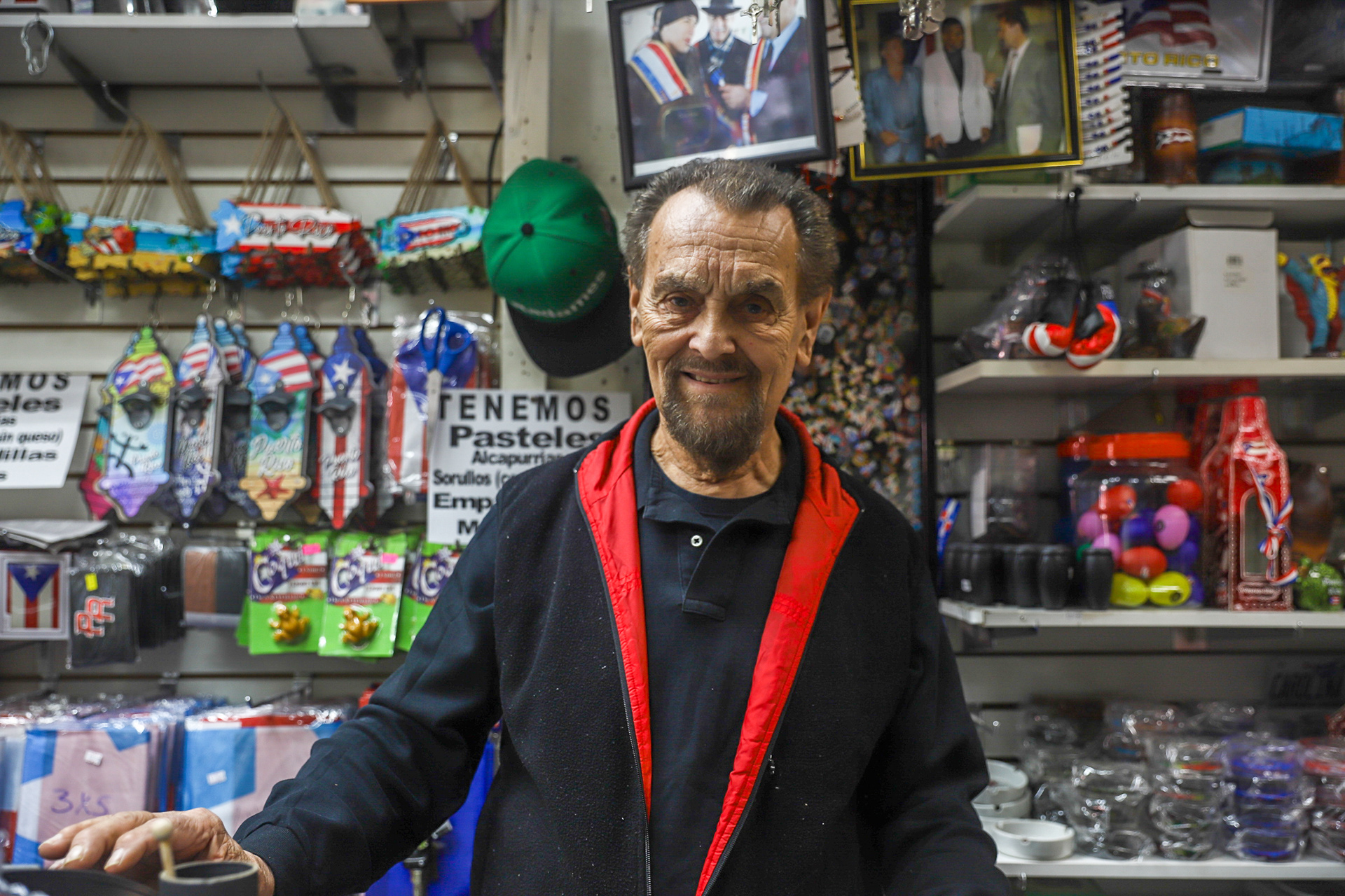 The owner, Radames Millan poses behind the counter, showcasing all types of Puerto Rican themed souvenirs.