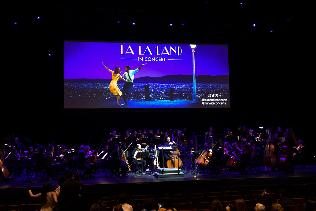 Caption: Members of the live orchestra and jazz ensemble tune their instruments on stage before a “La La Land” concert screening at Meridian Hall in Toronto on Saturday, March 7, 2026. Camera Settings: 1/60, ISO 1600, f/3.5