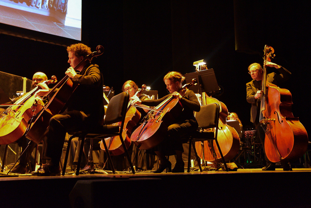 Caption: Cellists and bassists from the orchestra perform the emotional “Epilogue” sequence during a “La La Land” concert screening at Meridian Hall in Toronto on Saturday, March 7, 2026. The musicians played through the film’s bittersweet climax as the energy in the room shifted to a quiet, emotional state. Camera Settings: 1/25, ISO 2800, f/2.8