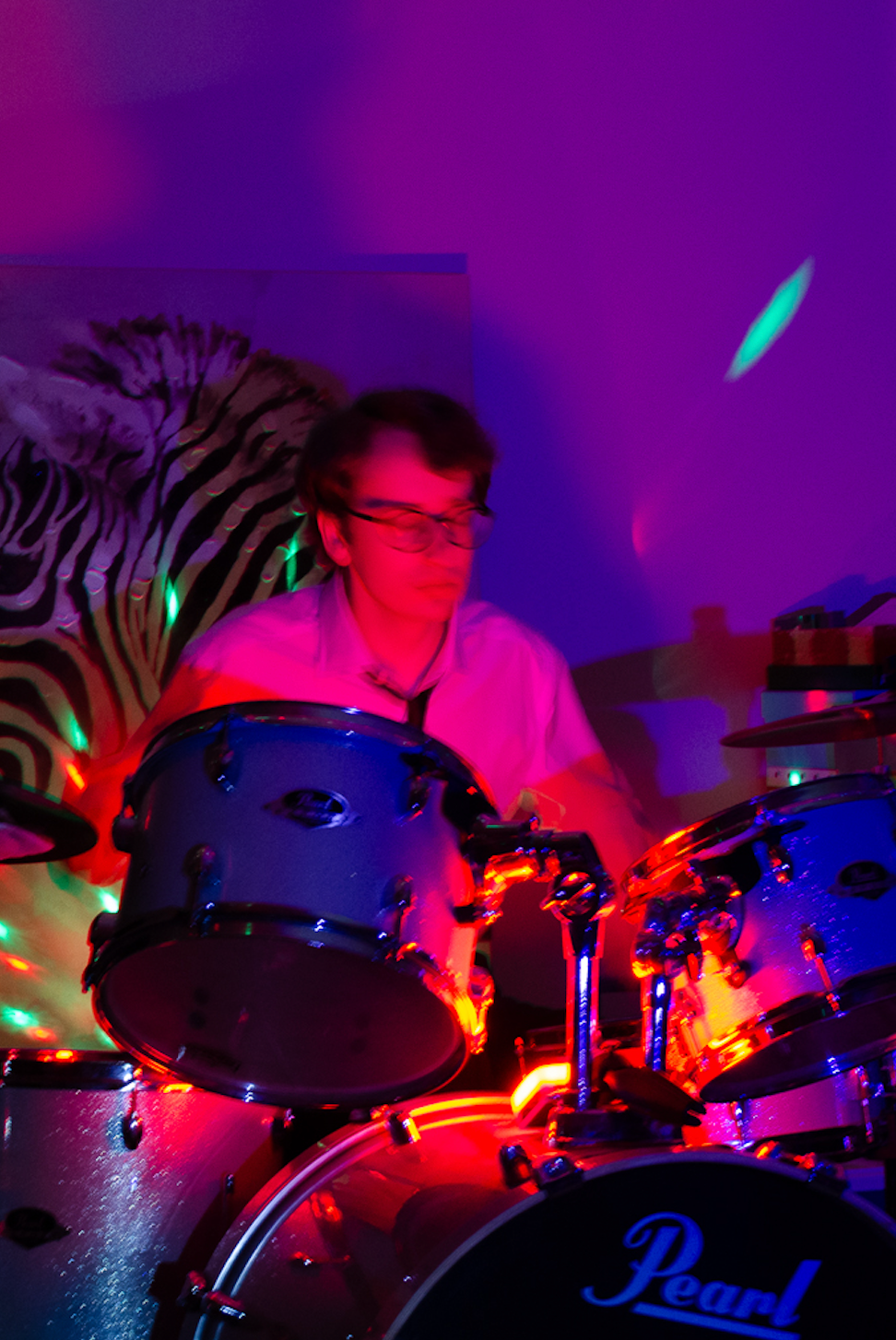 Caption: Toronto-based musician Andy Wright plays his drum kit under red stage lights during a practice session in Toronto on Saturday, Feb. 21, 2026. Wright channelled his recent personal experiences into the rehearsal, focusing heavily on writing and playing tracks for his upcoming independent EP. Camera Settings: 1/300, ISO 1600, f/4.0