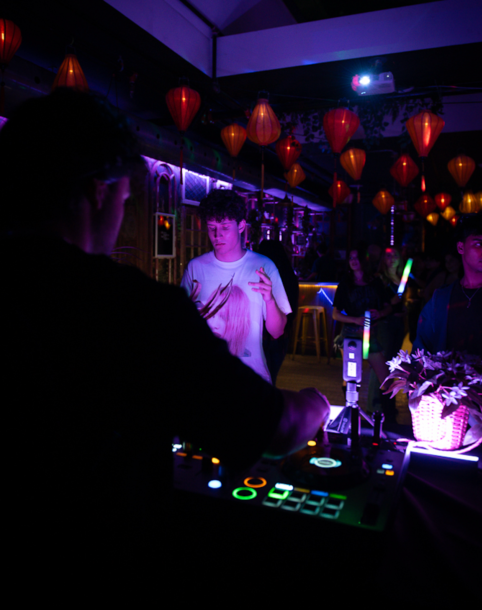 Caption: DJ Derose, left, watches from the side of the booth as DJ Misha performs a live set at Bar Dem in Toronto on Thursday, Jan. 29, 2026. The local artists shared the stage to provide the musical entertainment for a lively and fun night out. Camera Settings: 1/60, ISO 2200, f/2.8
