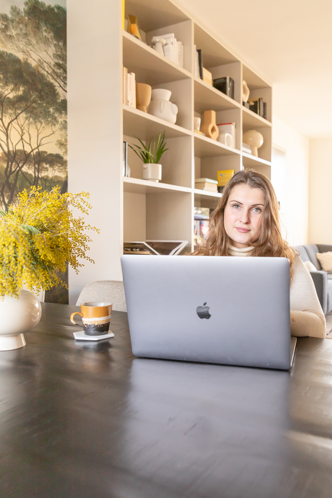 een vrouw achter de laptop in een mooi interieur
