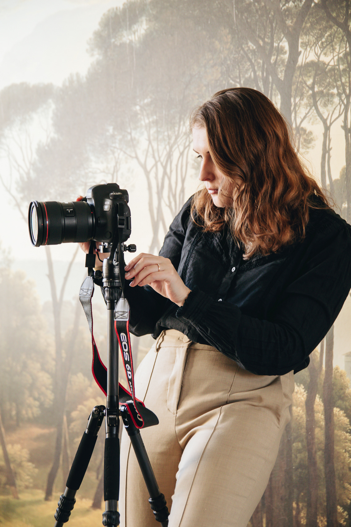 vrouw met een camera op een statief voor een behang