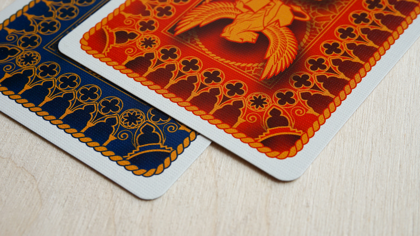 Macro view of Divinissimi Assi red and blue card backs — linen texture and fine offset printing by WJPC.