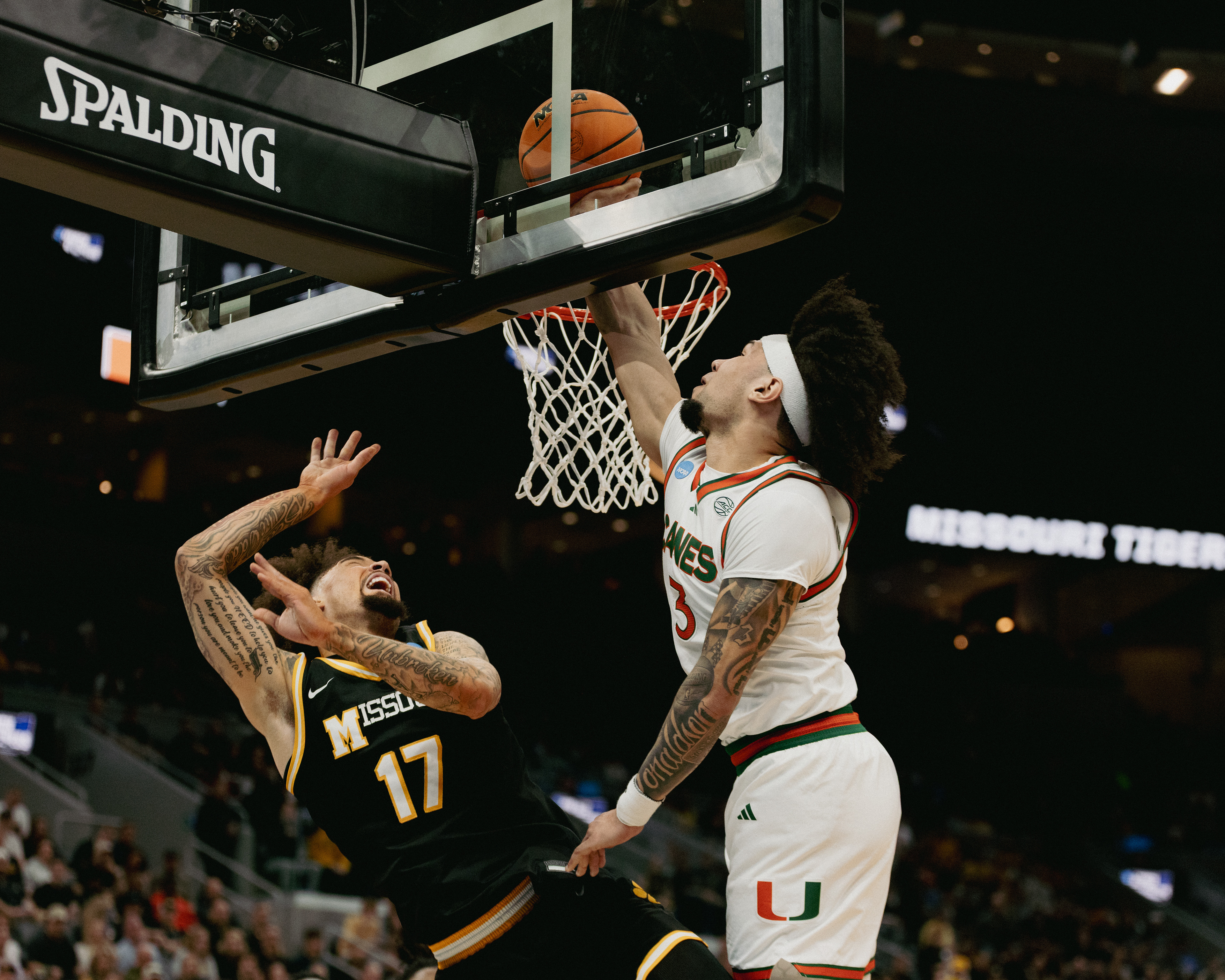 From left, Mizzou guard Jayden Stone (17) attempts an acrobatic layup as Miami guard Tre Donaldson (3) tries to deny the shot on Friday at the Enterprise Center in St. Louis. The Australlian, Stone led Missouri in scoring with 21 points in his final game as a Missouri Tiger.