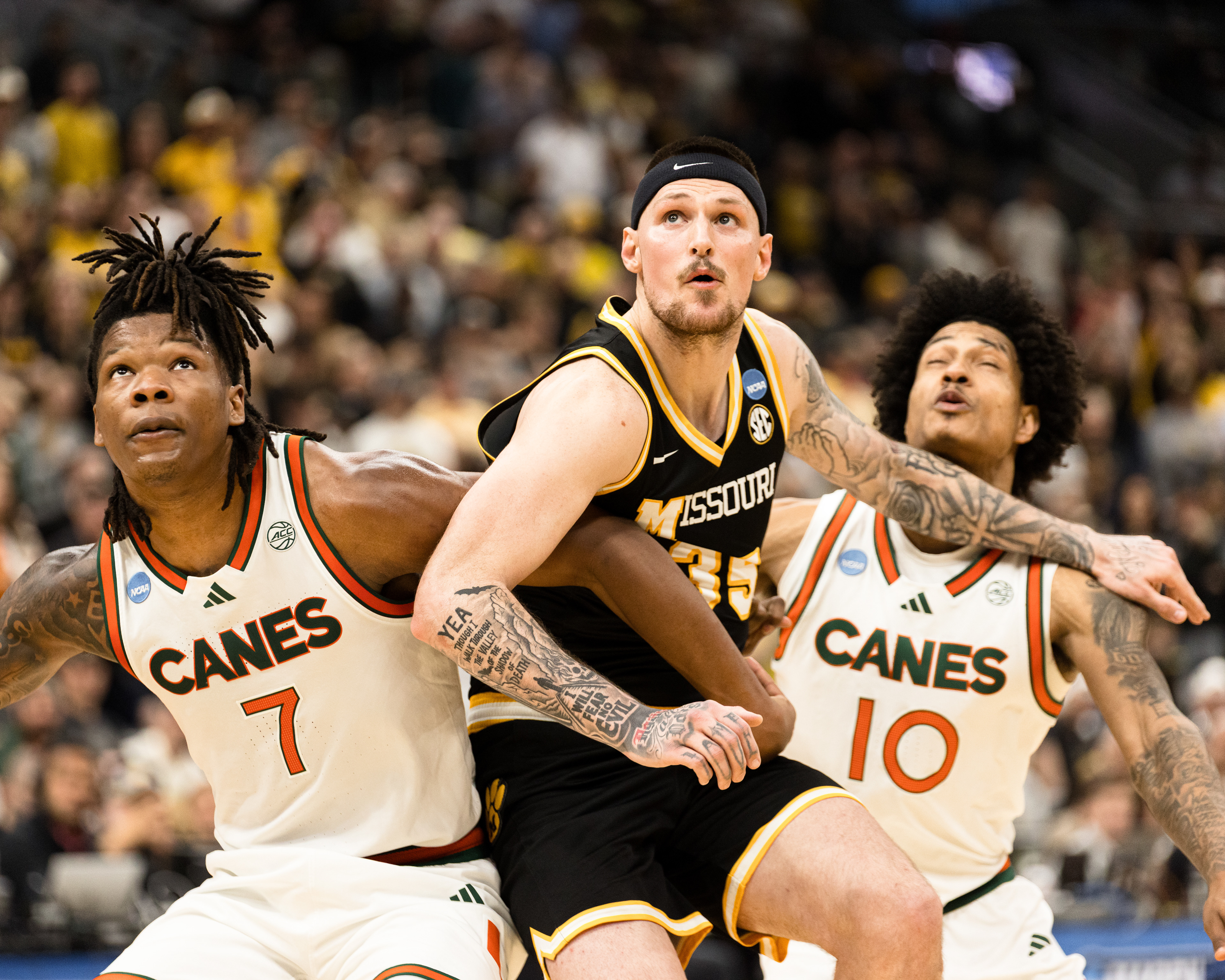 From left, Miami Hurriances' Shelton Henderson (7) and Tru Washington (10) defend Mizzou's Jacob Crews (35) during a free throw at the Enterprise Center on March 20, 2026 in Saint Louis, Missouri.