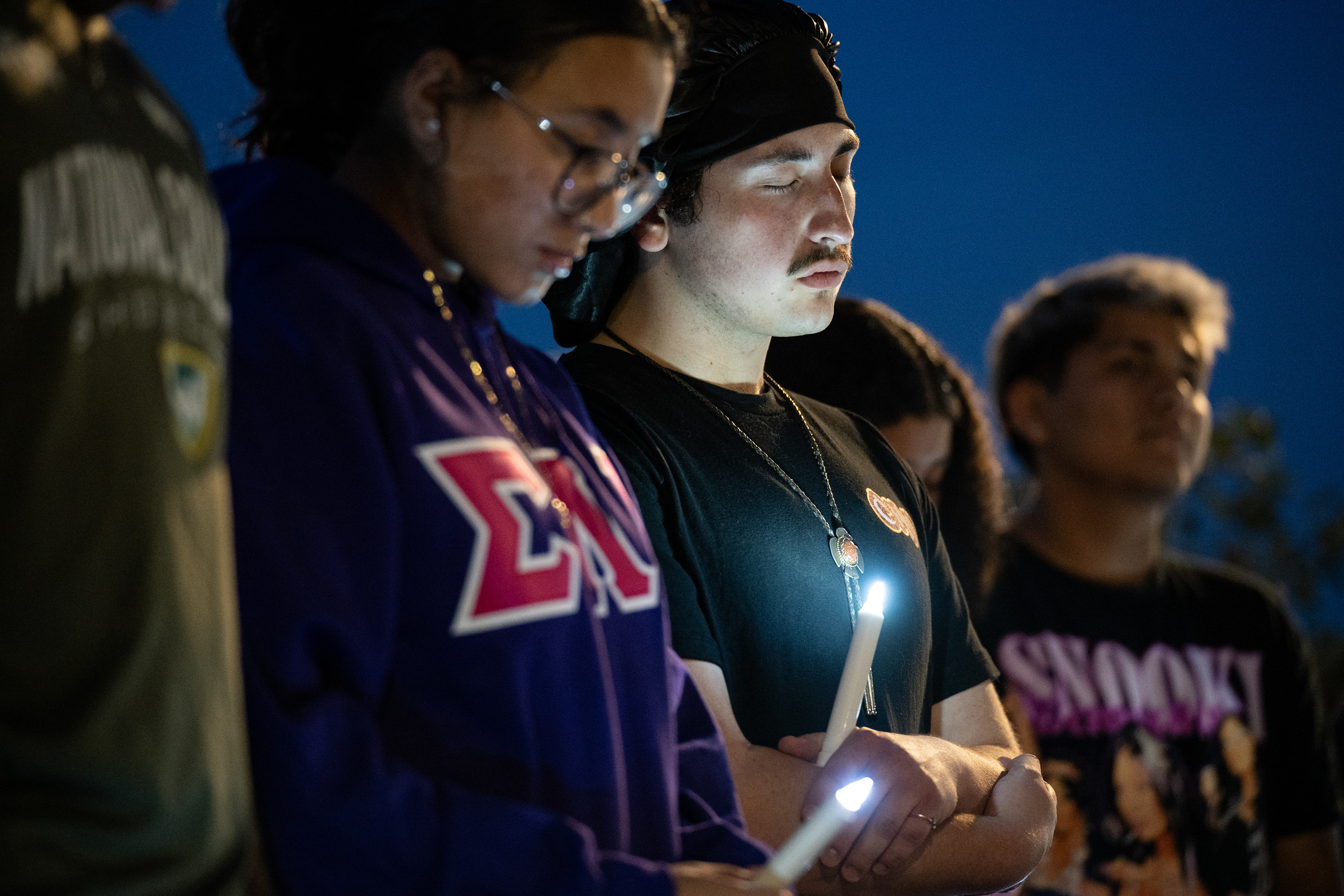 Central Michigan junior Treyven Salas-Peters and others bow their heads during a prayer at the candlelight vigil to honor the lives lost to school gun violence at Kesseler Circle, Wednesday, Sept. 17, 2025.