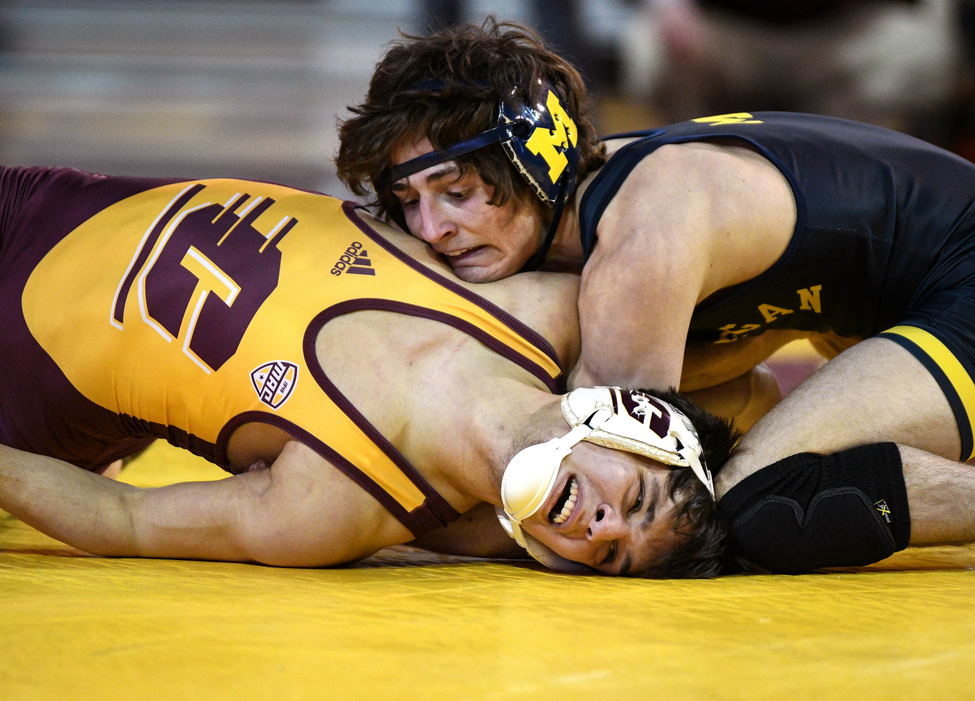 Central Michigan freshman Grant Stahl (left) gets held down by University of Michigan redshirt freshman Nolan Wertanen (right) during a match in McGuirk Arena in Mt. Pleasant, Mich., Sunday, Feb. 25, 2024.