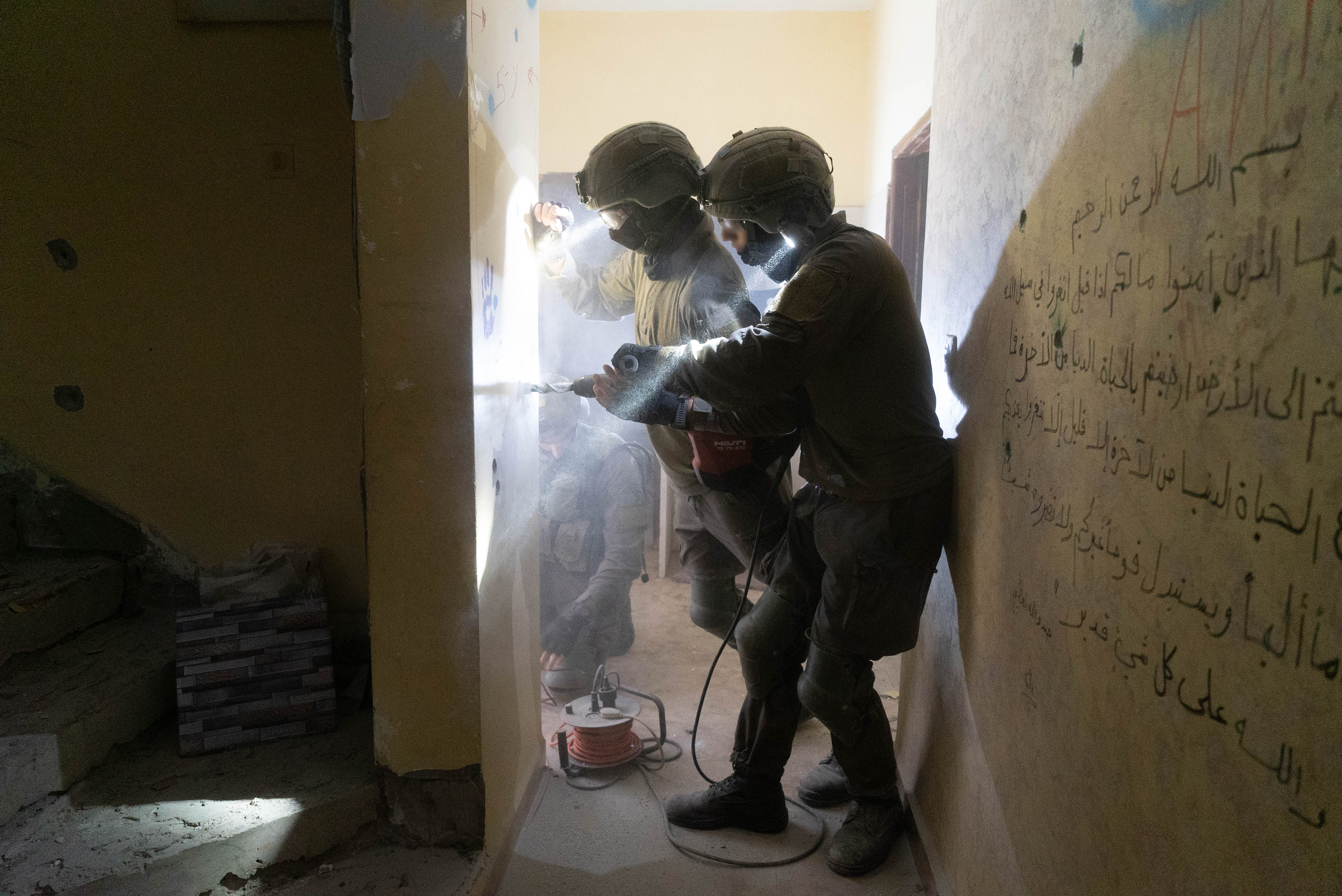 Soldiers placing explosives for the demolition of a home, Jenin December 2022.