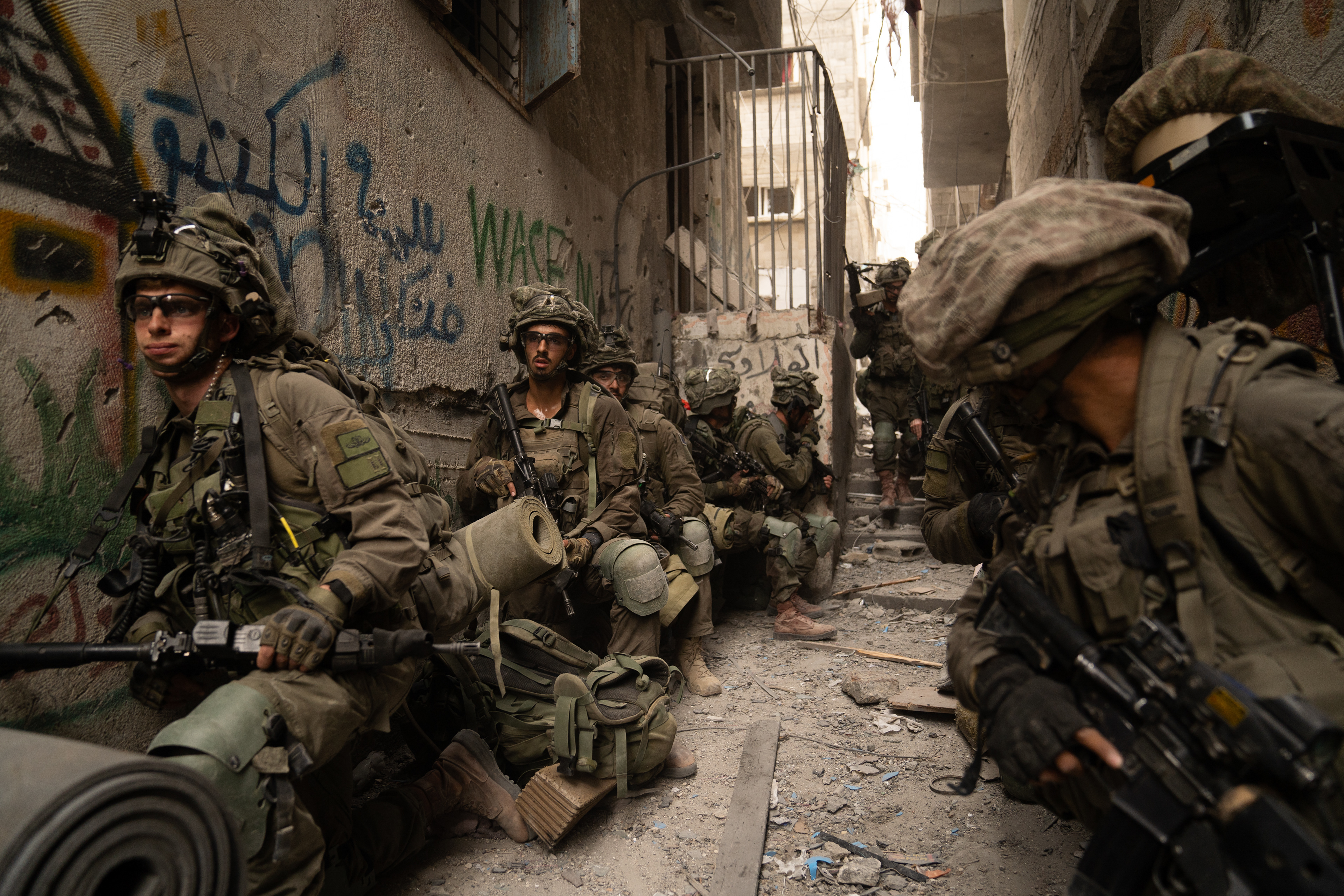 A platoon waits for orders to advance in the tight alleyways of Shati Camp.