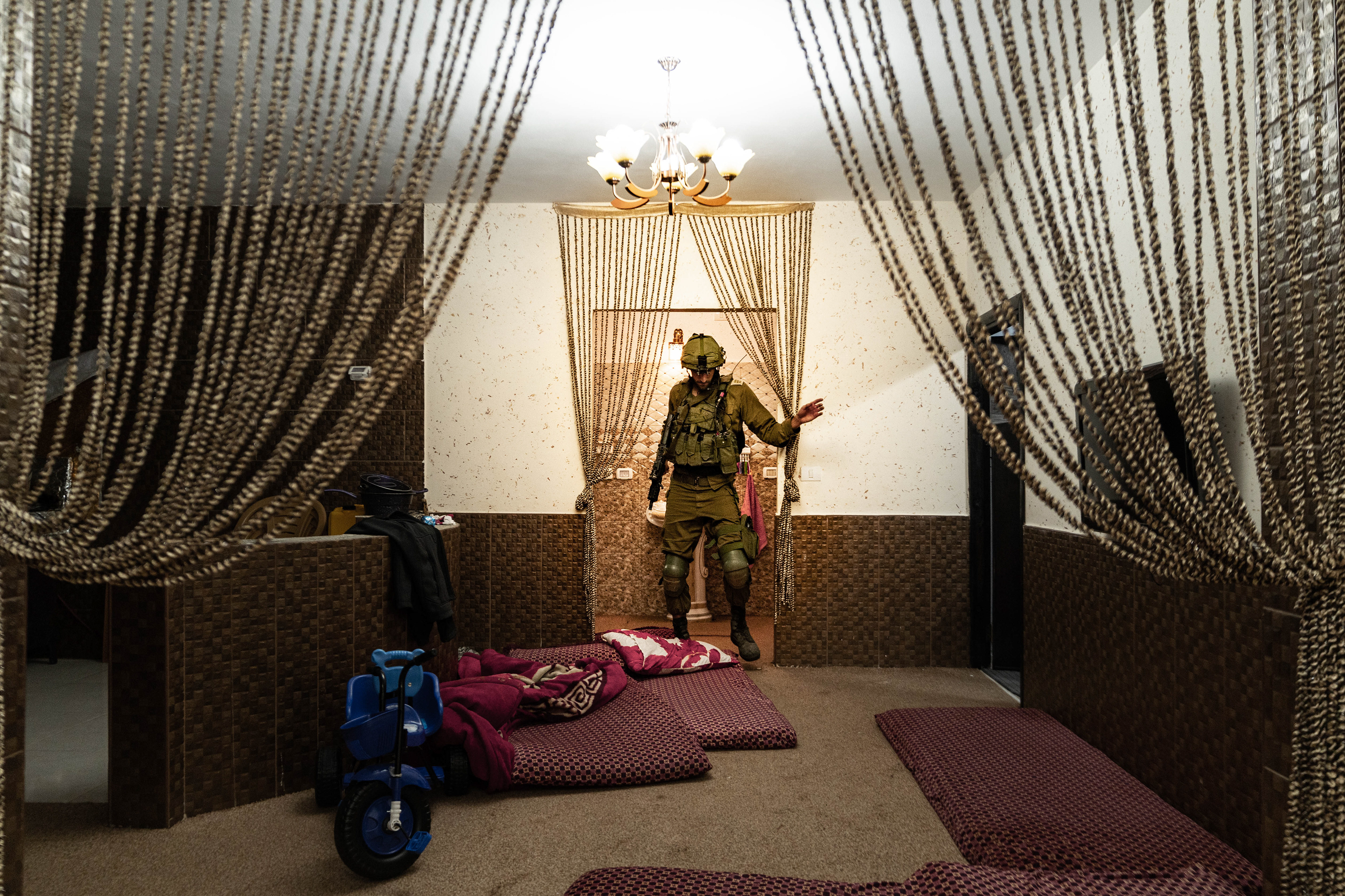 Soldier searching for weapons in a home in the Masafer Yatta region.
