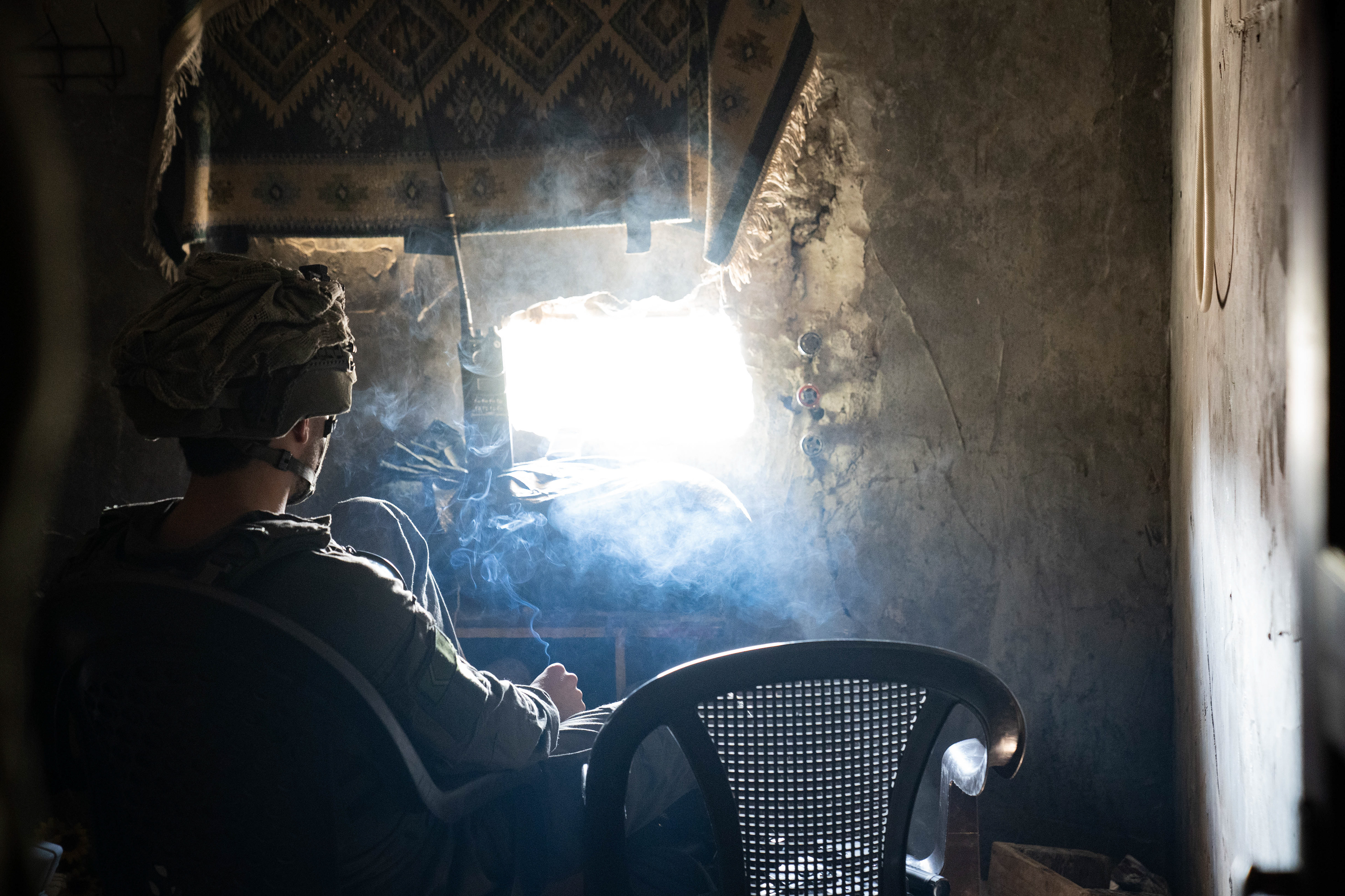 Cigarette smoke mixes with dust and debris in a defensive outpost in Khan Younis.
