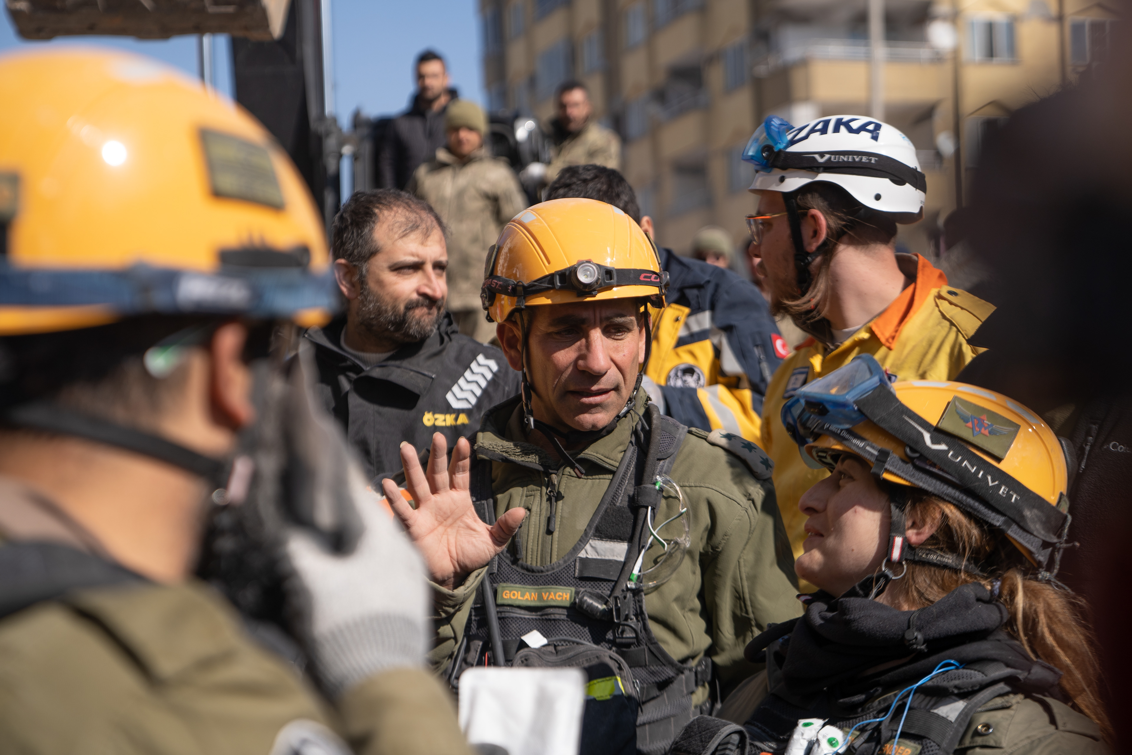 commander of the Israeli rescue unit surveying the site of an ongoing rescue attempt.