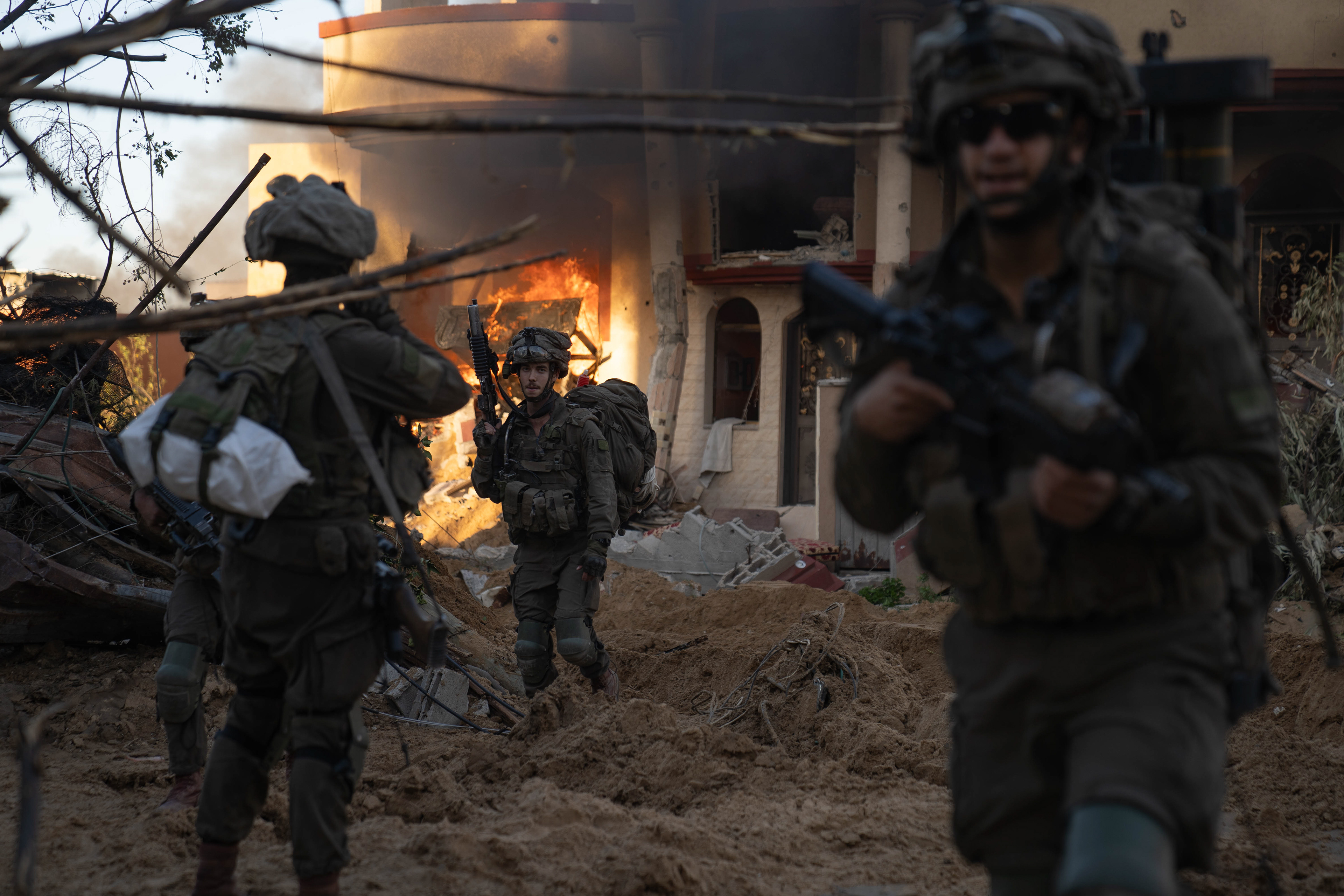 Soldiers evacuating from a burning building where a Hamas operative was found.