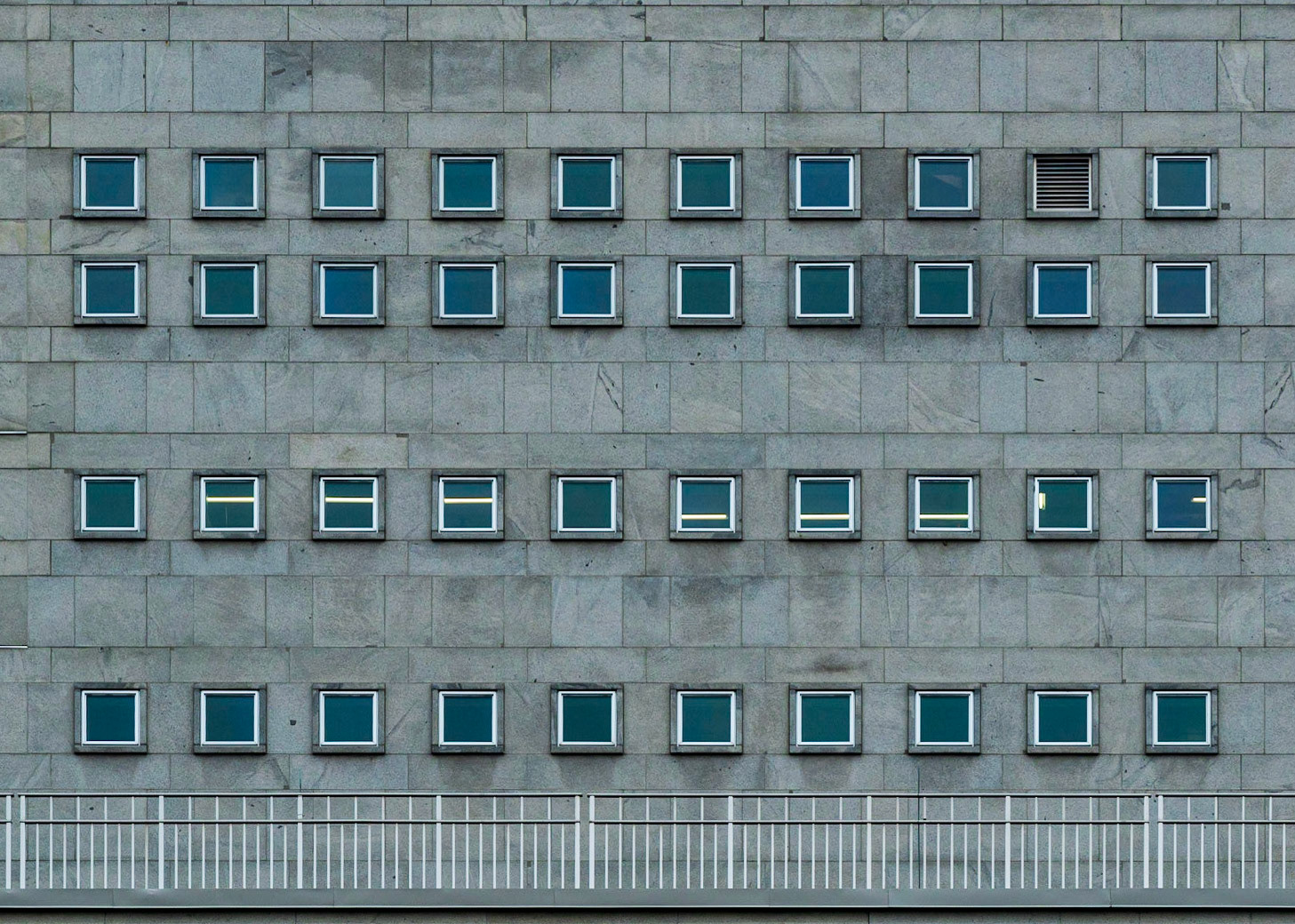 Repeating squares with small details that break the pattern. I particularly like how the ceiling lights in the third row from the top change position from one window to the other.