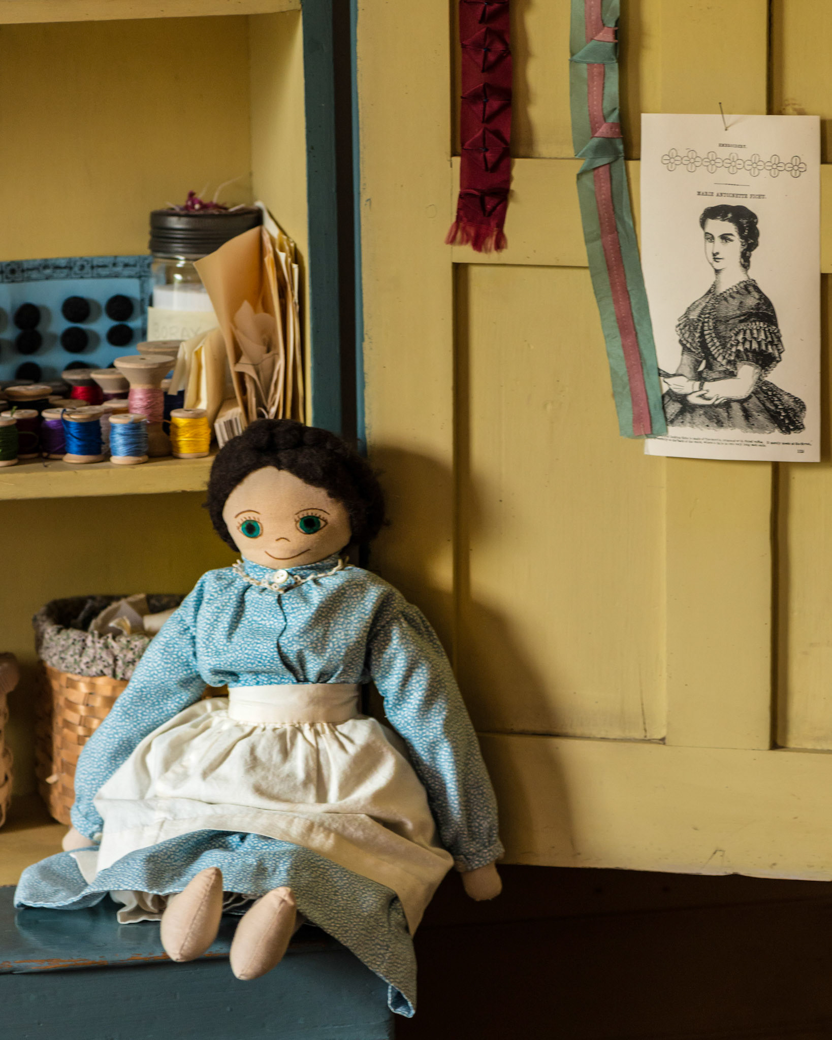 I find the juxaposition of the child's doll and the poster for the lady's dress interesting in this shot.