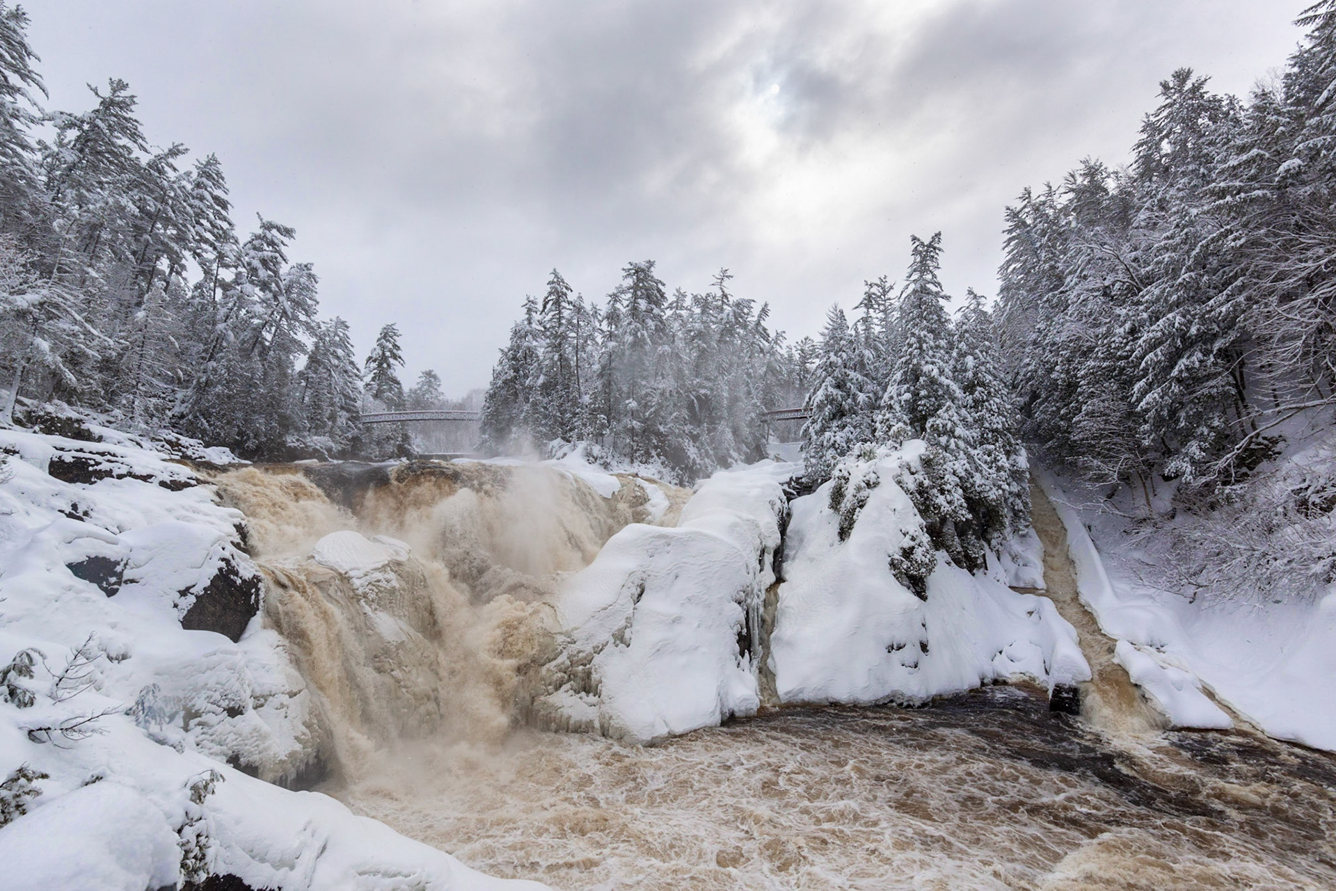 The view from the main observation platform, showing the falls on the left, the logging chute on the right, and the two walkway bridges in the background.