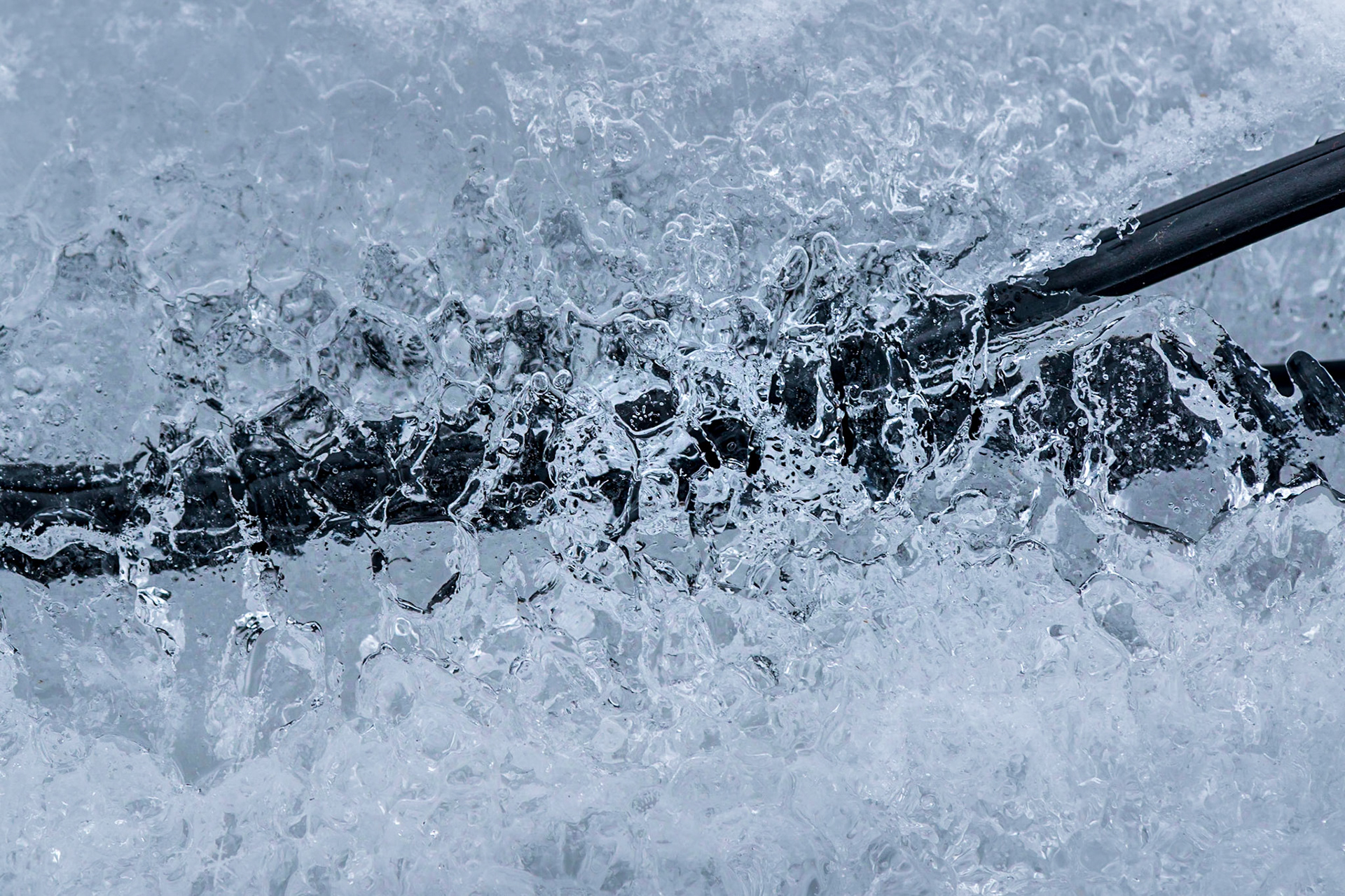 Electrical cable coated in ice, which I’ve flipped horizontally and vertically. The main subject is the texture of the central ice crystals which are more easily visible with the dark cable in the background.