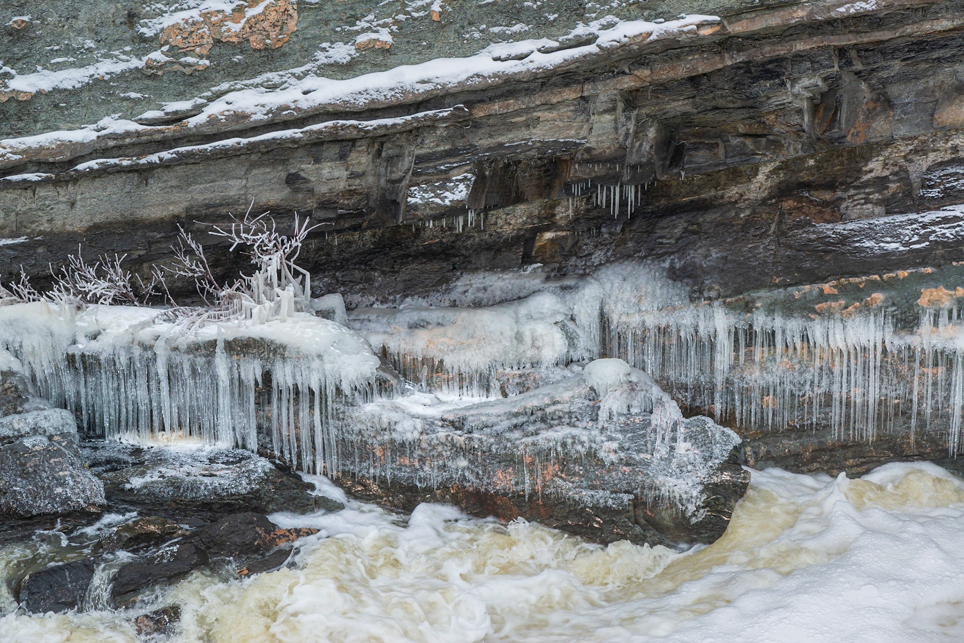 The diverging diagonal lines partition this shot into three or four contrasting regions. We have the unusual green coloured rock at the upper left, grey rock and ice in the center, and foamy water at the lower right.