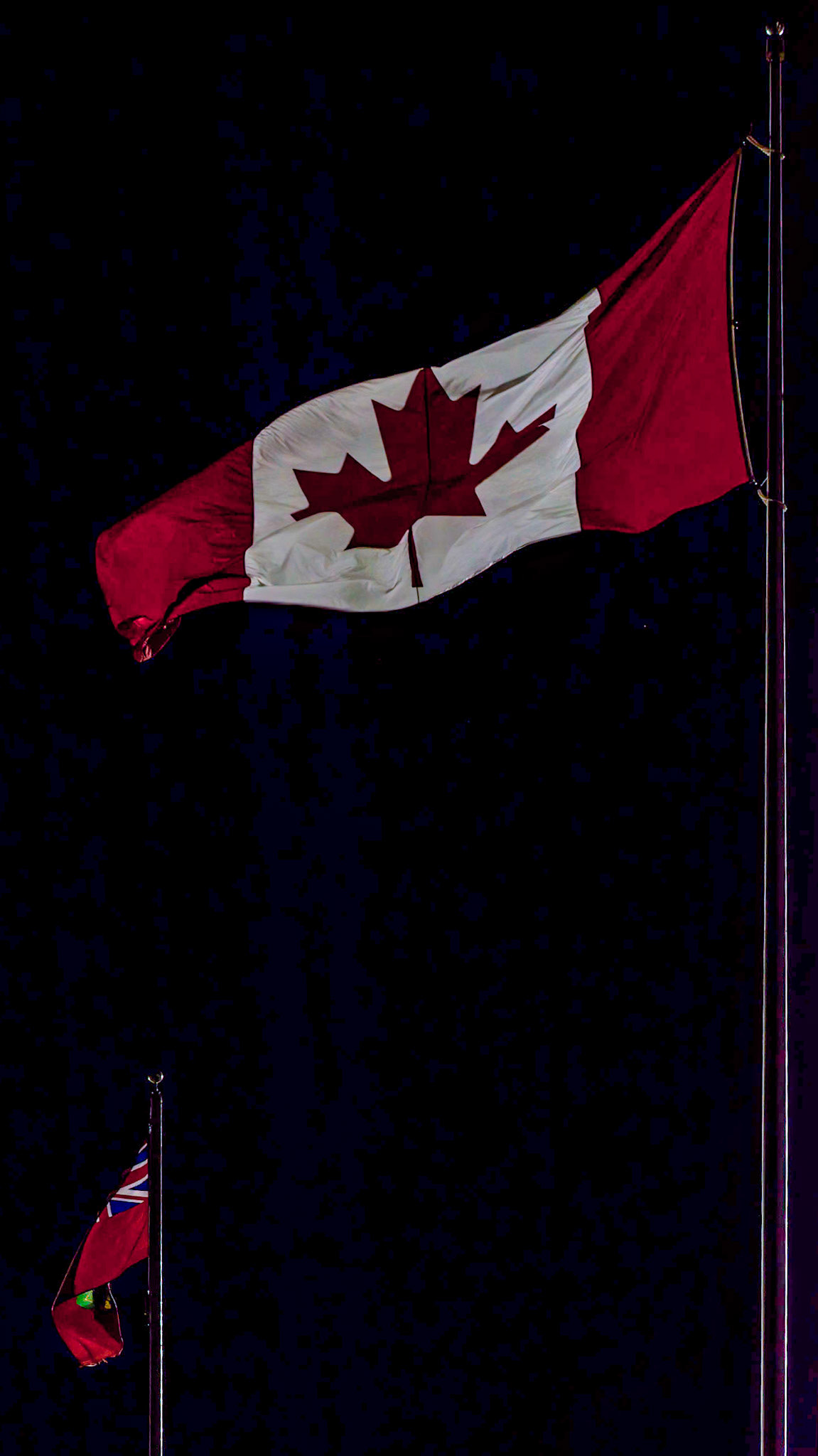 Canada and Ontario flags at TD Place Stadium. [ISO 6400, 105 mm, f/8.0, 1/100s]