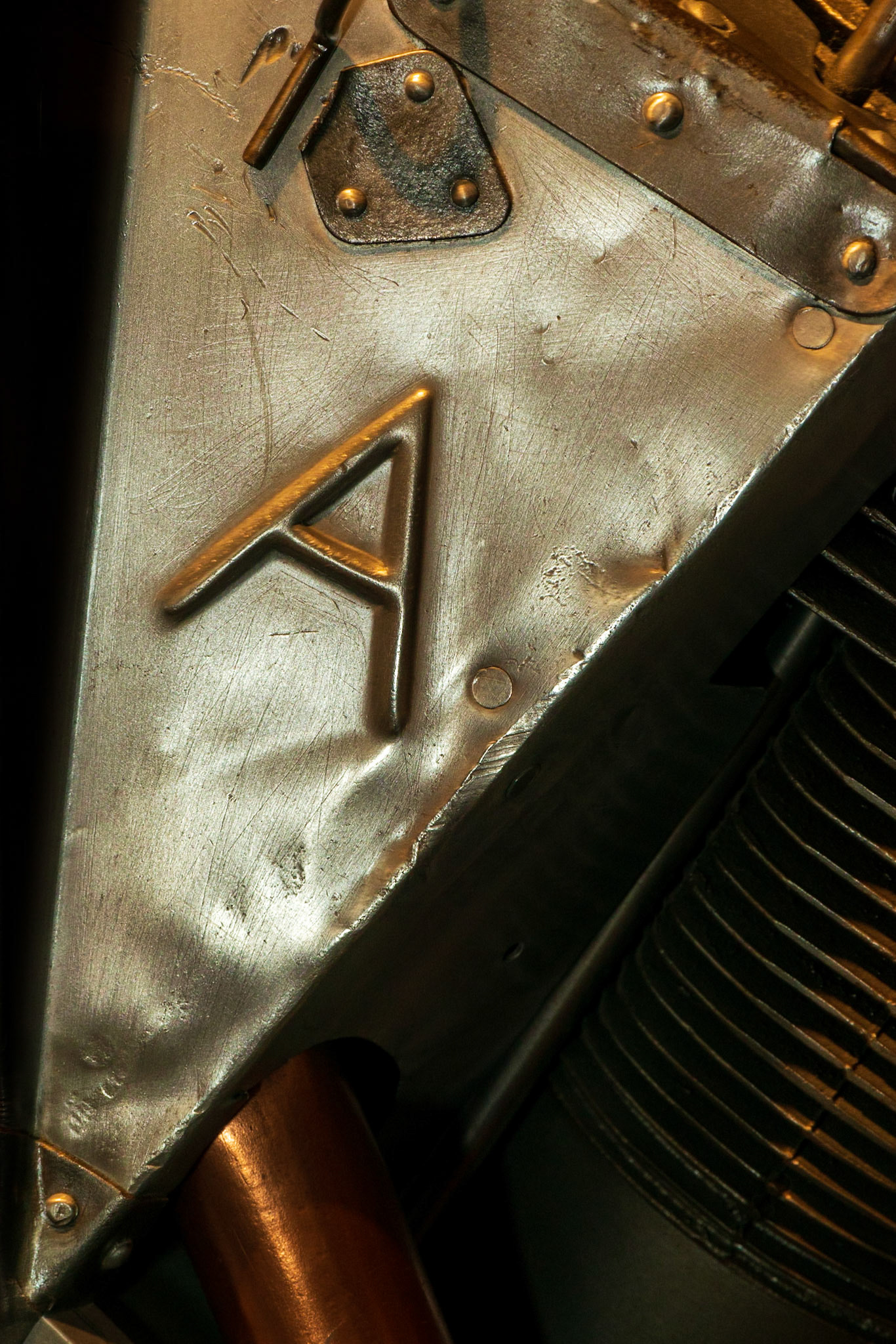 There are several triangles in this shot. The letter “A” draws our attention and forms one triangle, the metal on which it is stamped is another triangle, and the negative space forms other triangles.