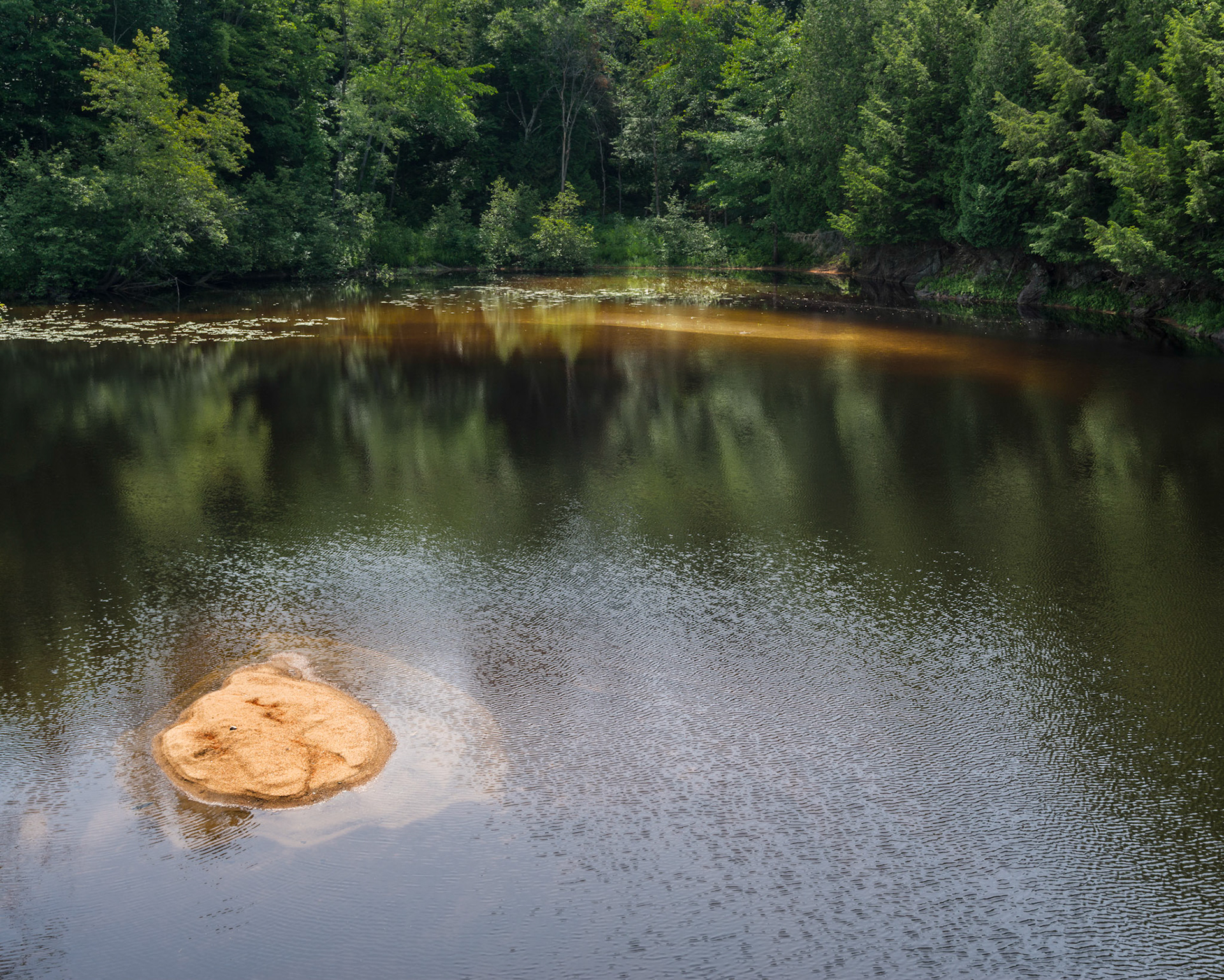 Looking away from the waterfall, I found this scene of red stone and green forest in a calm pond.