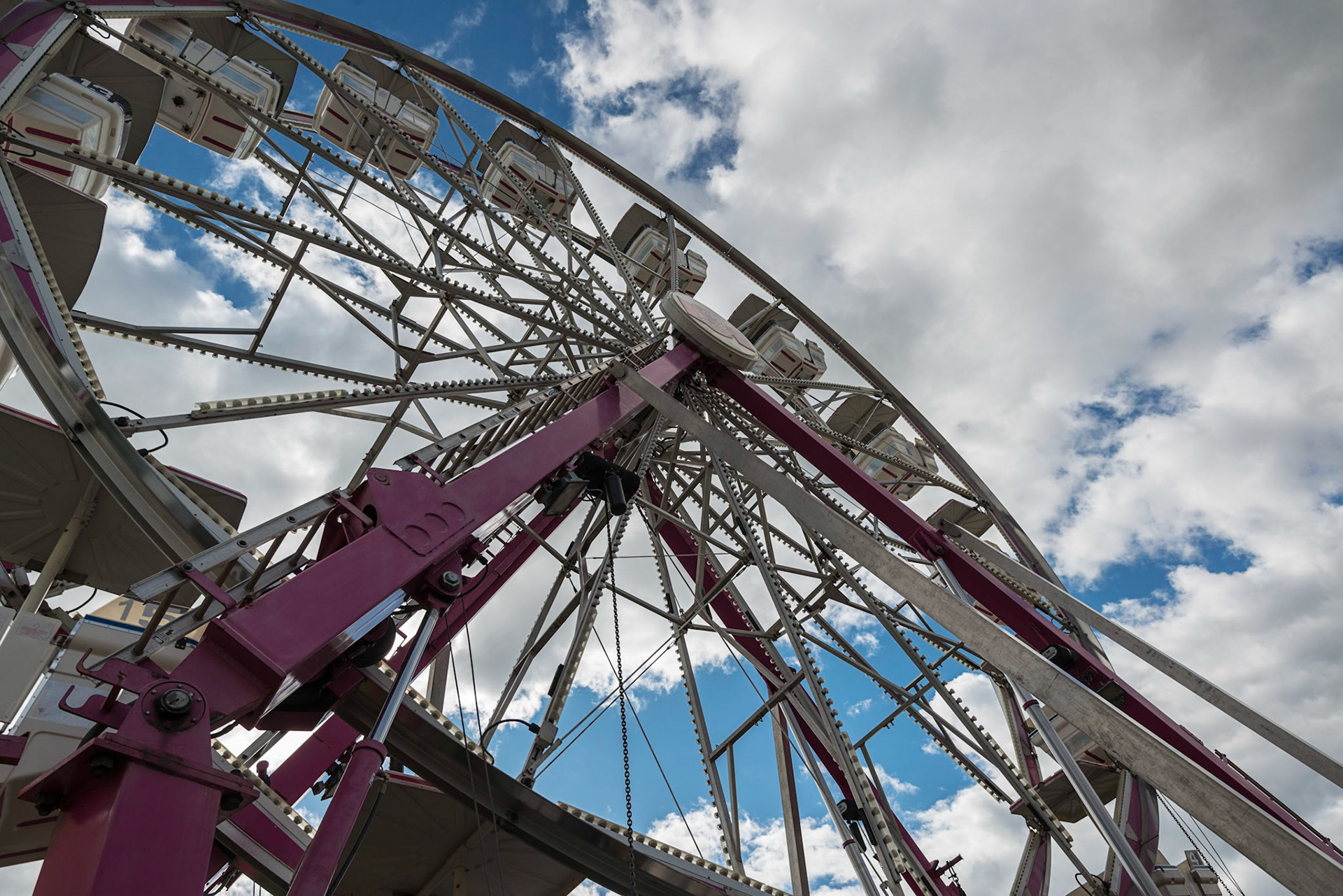 This unusual perspective emphasizes the height of the ferris wheel and contrasts it's shape against that of the clouds.