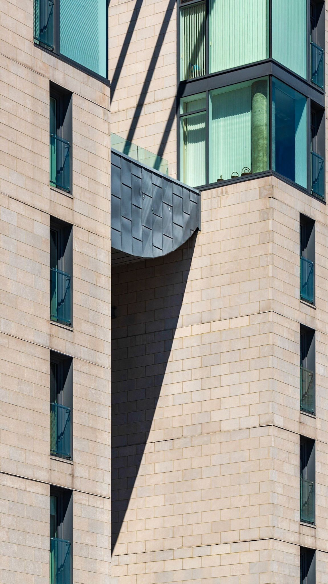 What intrigued me with this shot was the triangular shadow below and the three lines of shadow above. I chose to frame them between the rectangular windows on either side.