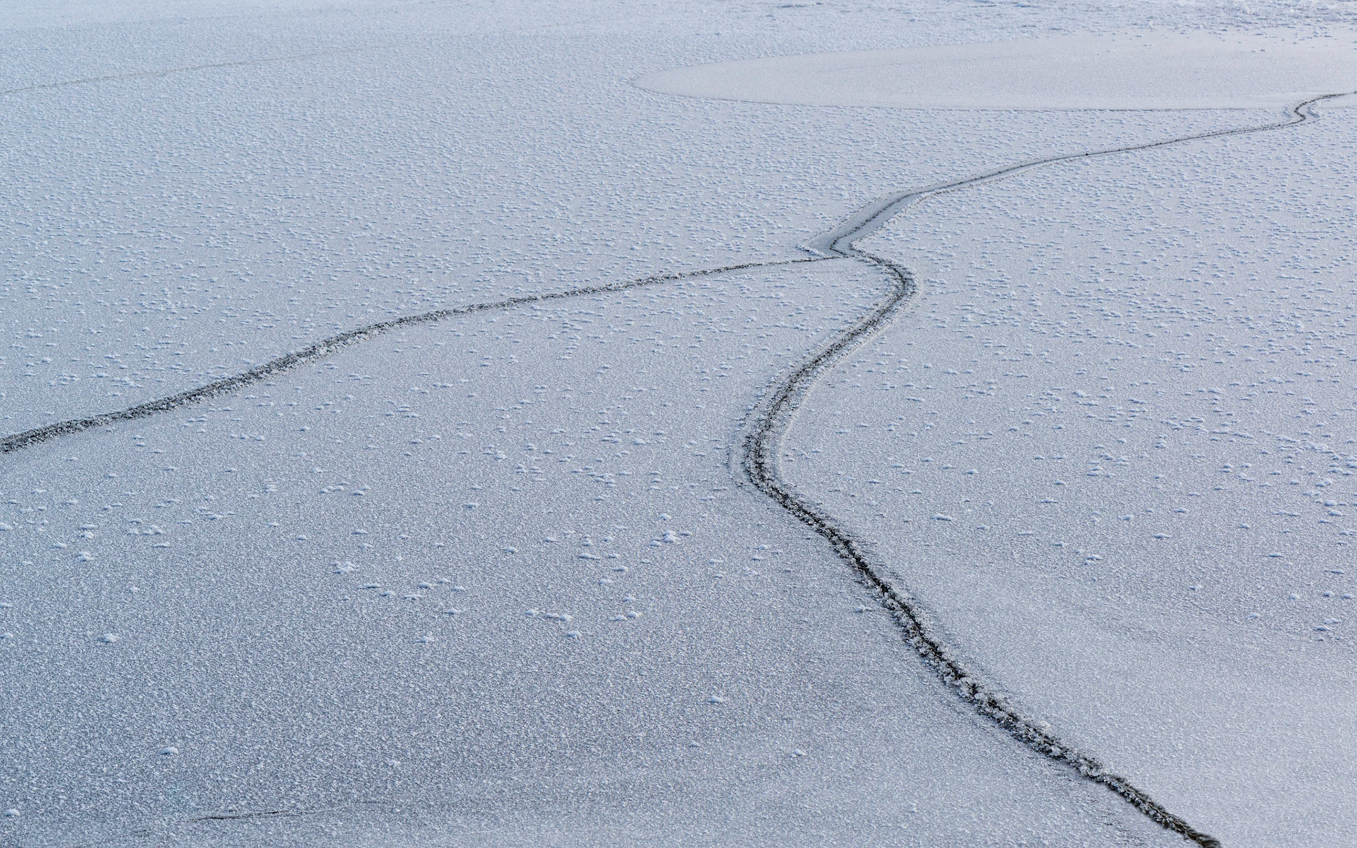 I was seeking a very graphic shot here, using the crack in the ice as the dominant element. The high contrast of the crack in the lower right foreground attracts the eye. From that point, the crack brings us to the circular shape at the upper right.