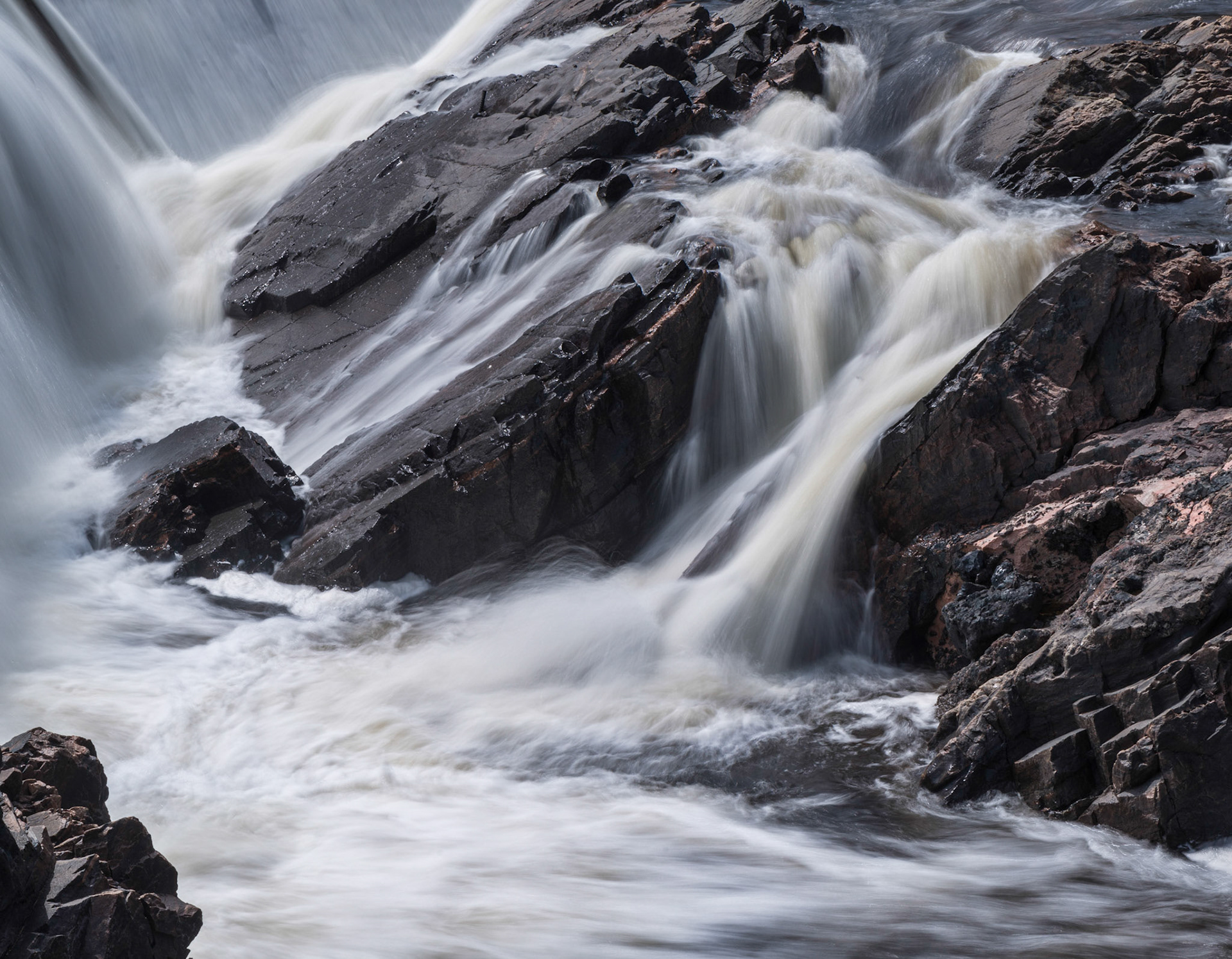Water pours over a man-made barrier at the upper left of this shot and begins it's journey to the gorge below.
