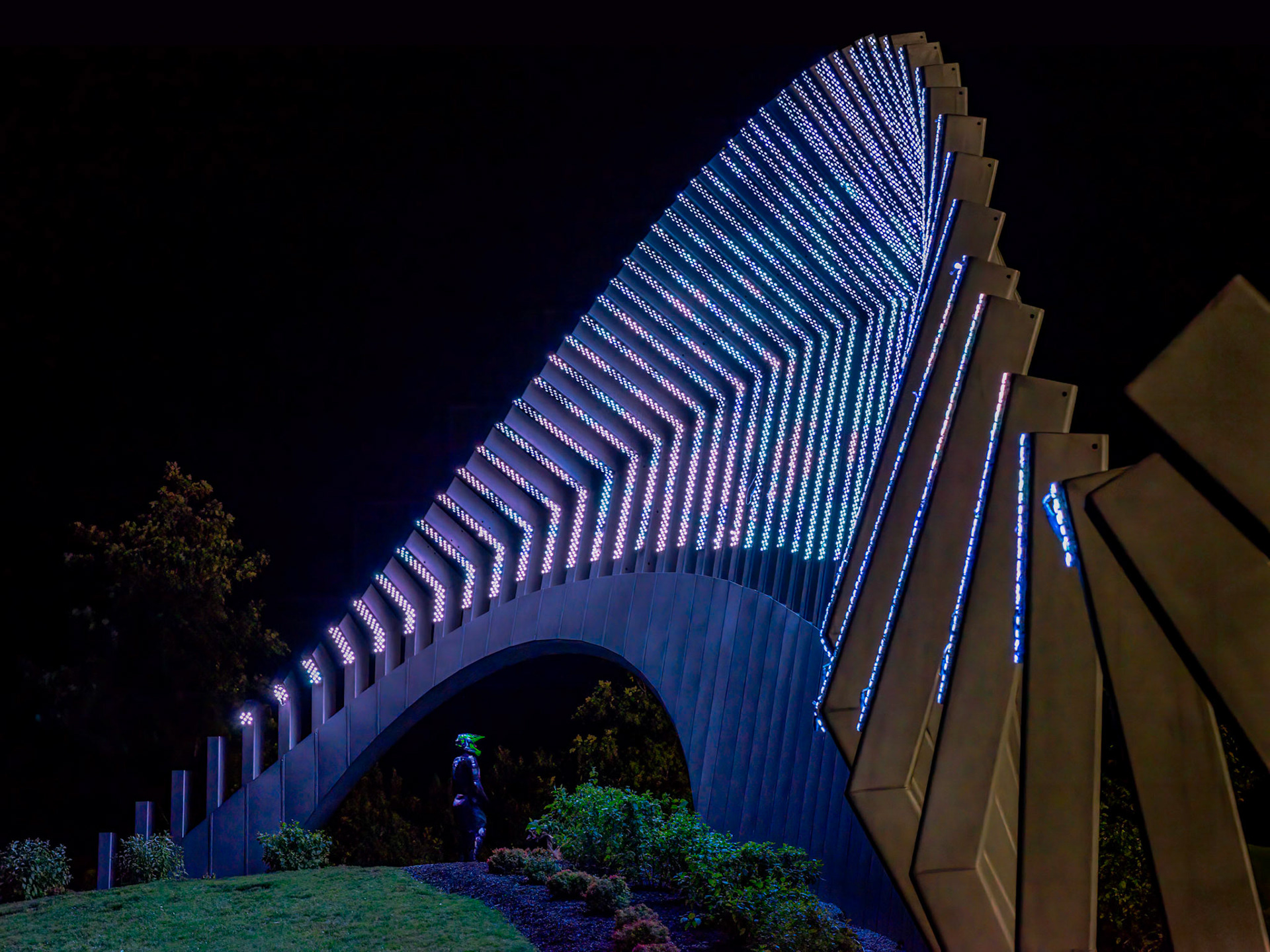 Moving Surfaces sculpture by Jill Anholt Studio, with a visitor. [ISO 6400, 105 mm, f/8.0, 1/100s]