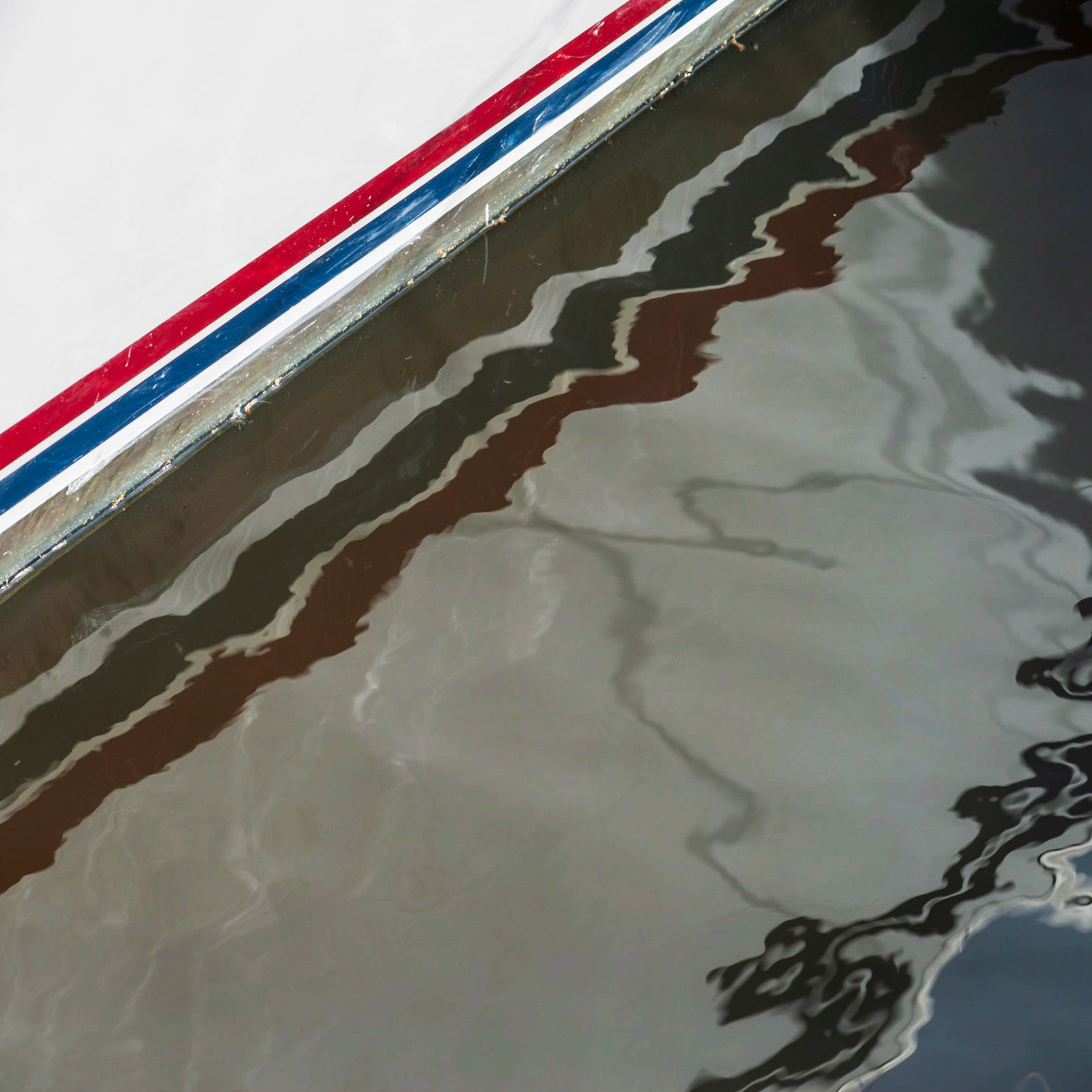 Reflections are fascinating, whether the medium is water, glass, or ice. Here, I was intrigued by how the strong lines on the boat were altered by the water.