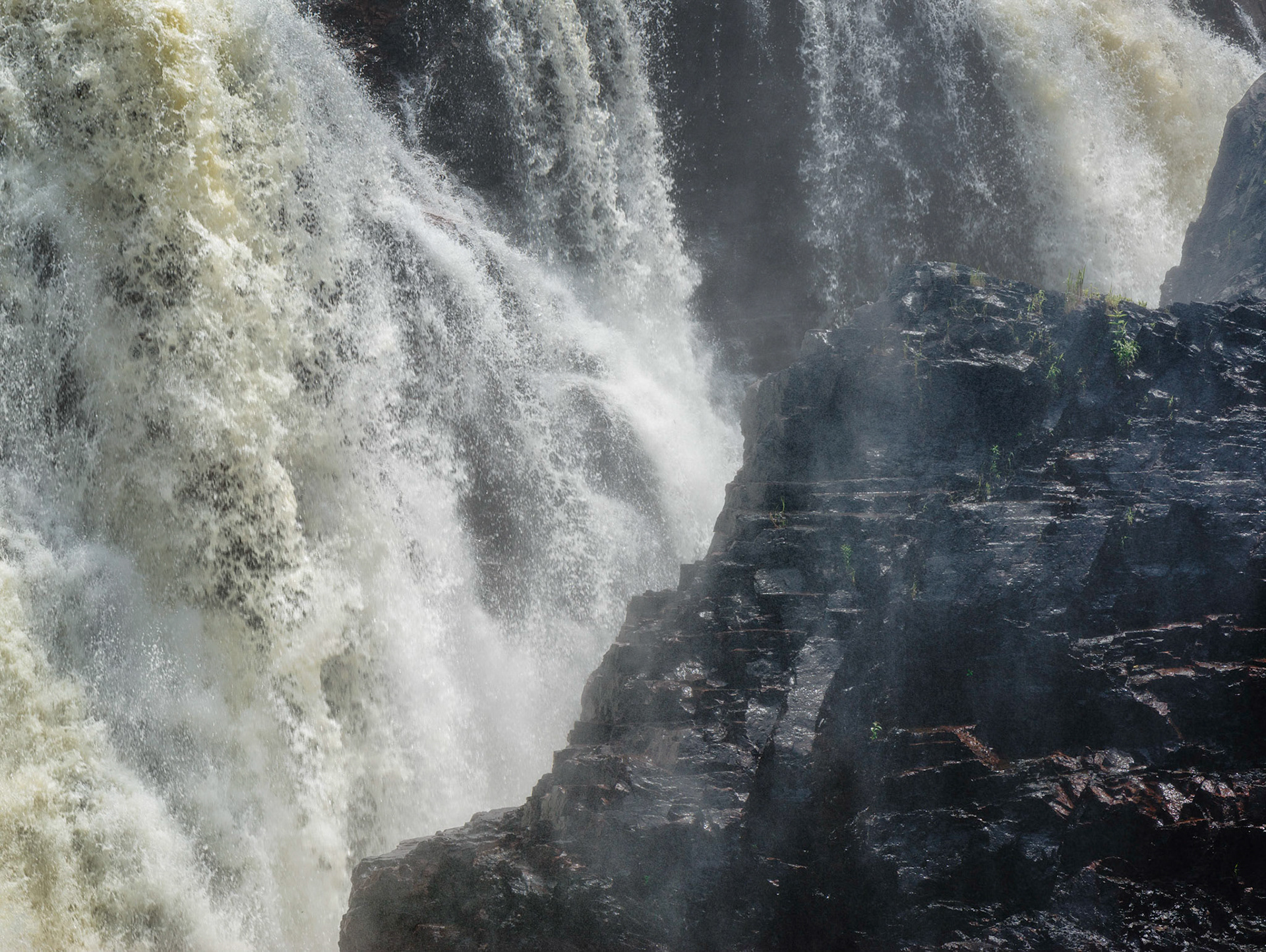 A veil of mist does little to hide the power of the impressive Coulonge waterfall.