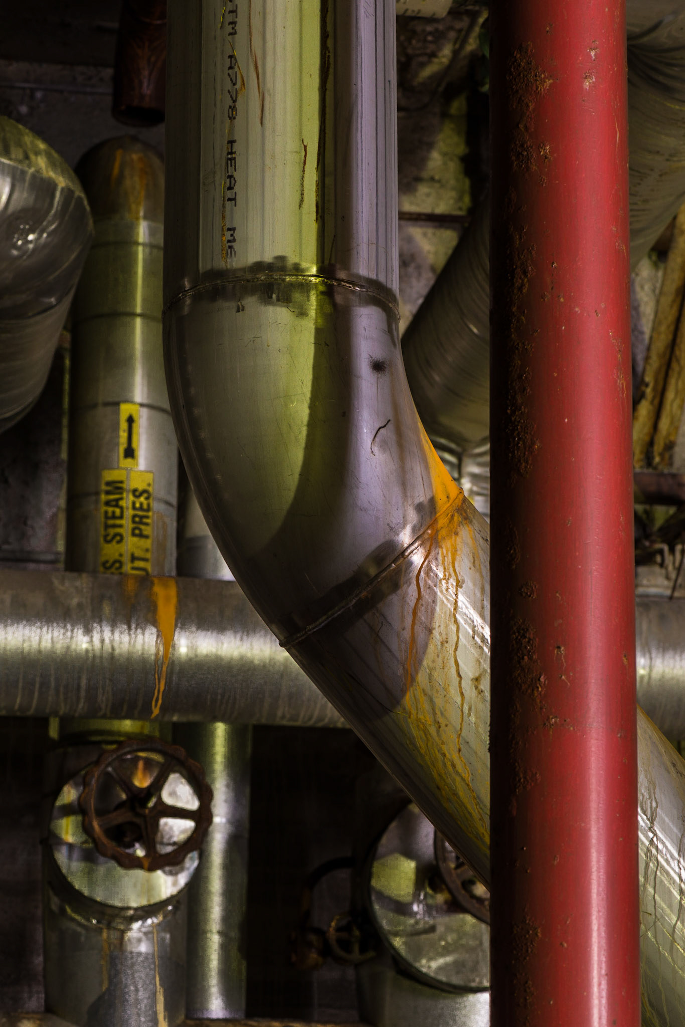 The green comes from reflections and the greenish light in the area, and complements the bold statement of the dominant red pipe