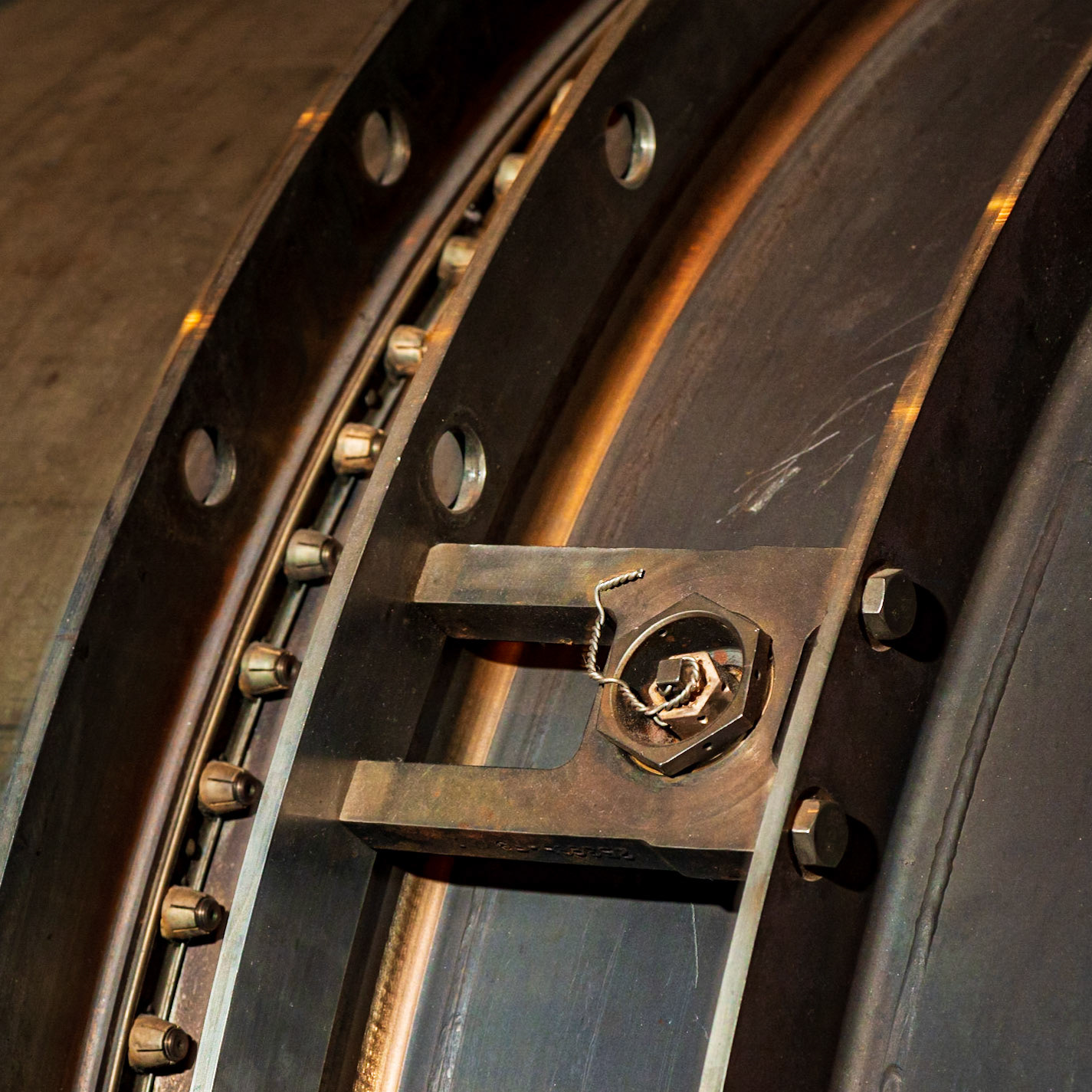 This is a tiny part of a large engine. The arcs create a visual flow to the upper right, but the cross member with its nut and wire break the flow and draw the eye.