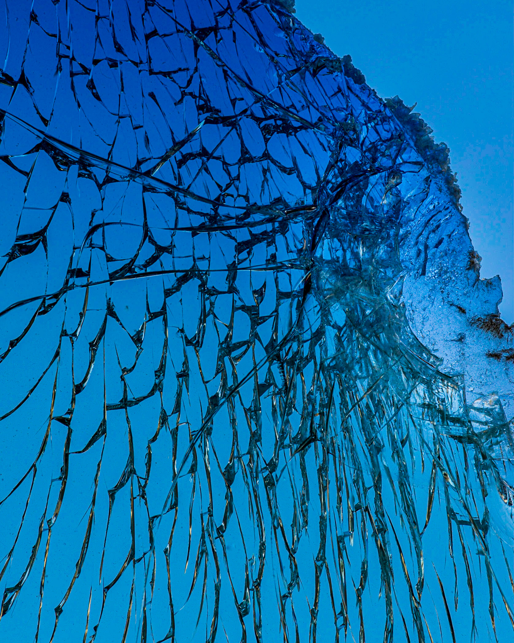 This again is a broken windshield, forming lines radiating from a semi-circular area on the edge. In this case, I could not see the shot, and several tries were needed, since the camera was pointed upward to the blue sky.