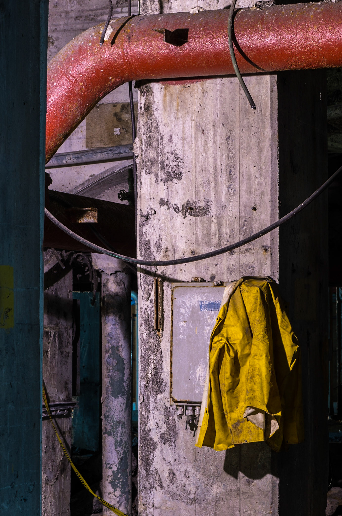 The juxaposition of the yellow jacket with the red pipe is the main subject here, with some additional interest provided by the blue lighting on some of the beams