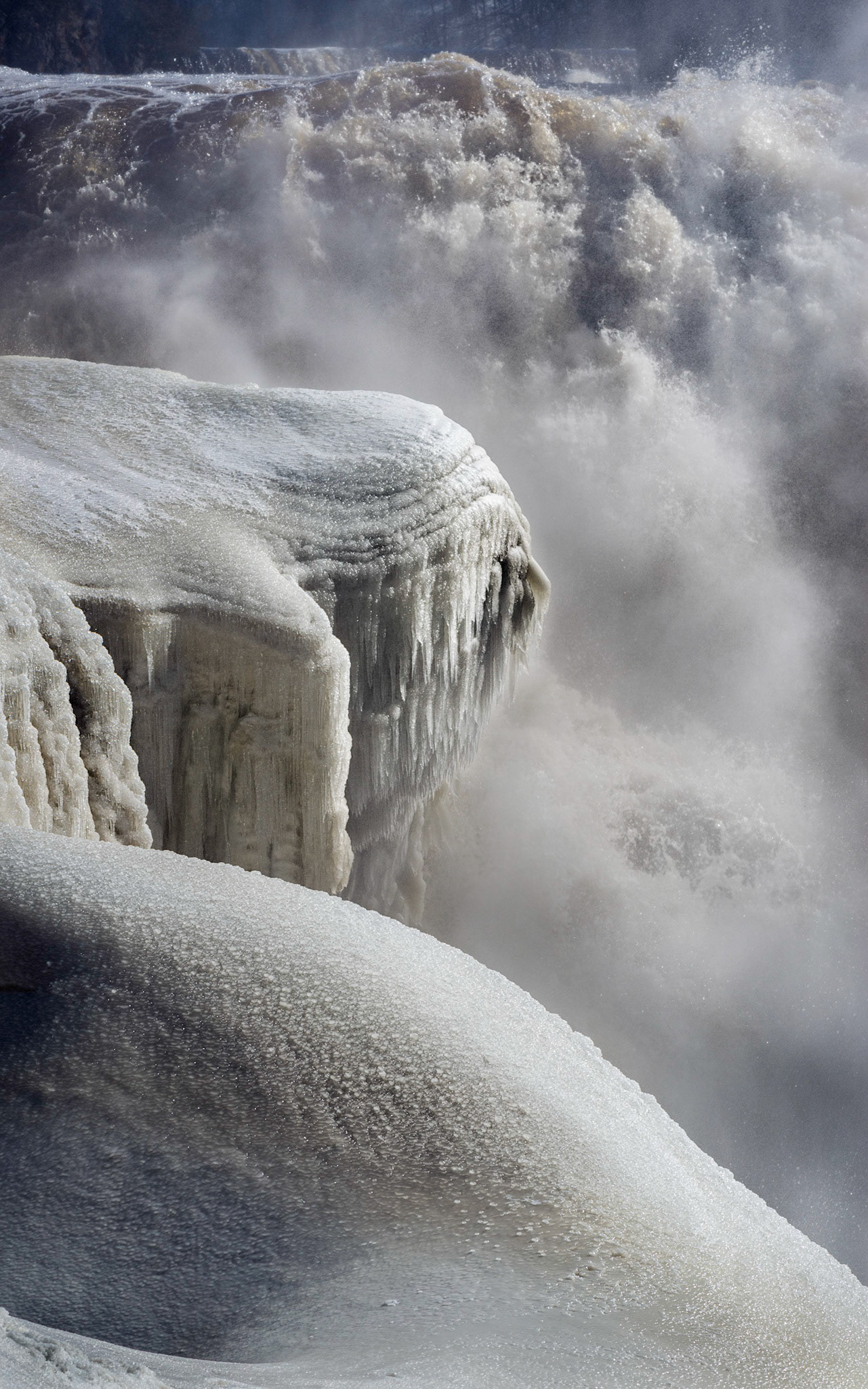 This shot was framed to show three layers depicting states of water: snow, ice, and running water, all surrounded by mist.