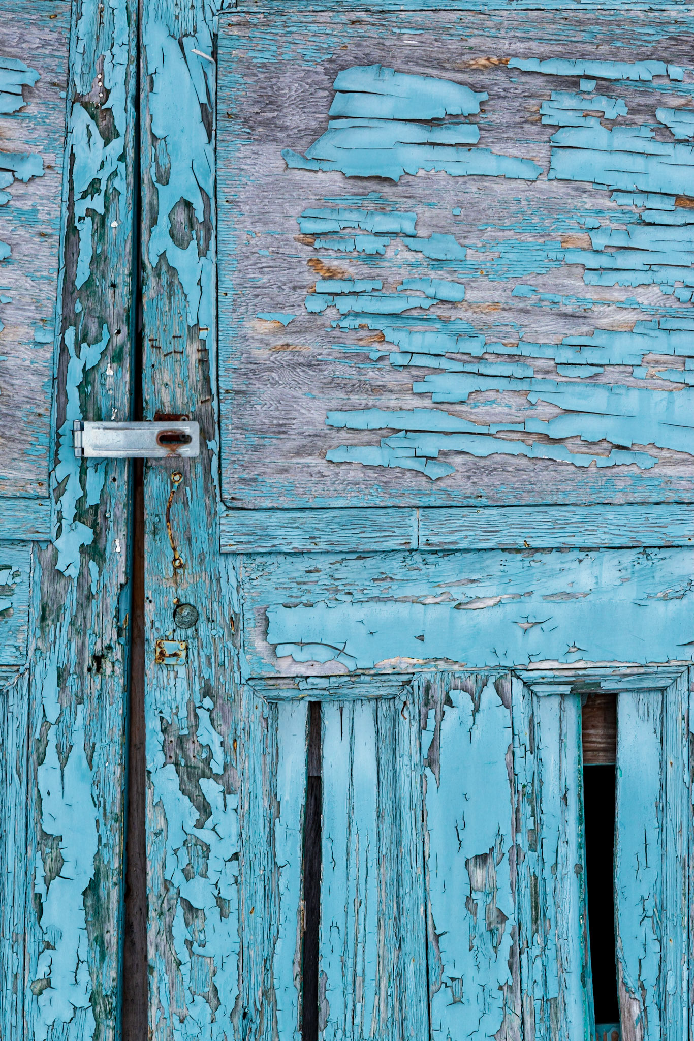 This shot is mainly about texture. The silver door hasp provides a center of interest, and I’ve arranged the two missing door boards at the bottom to balance the square door pane at the top.