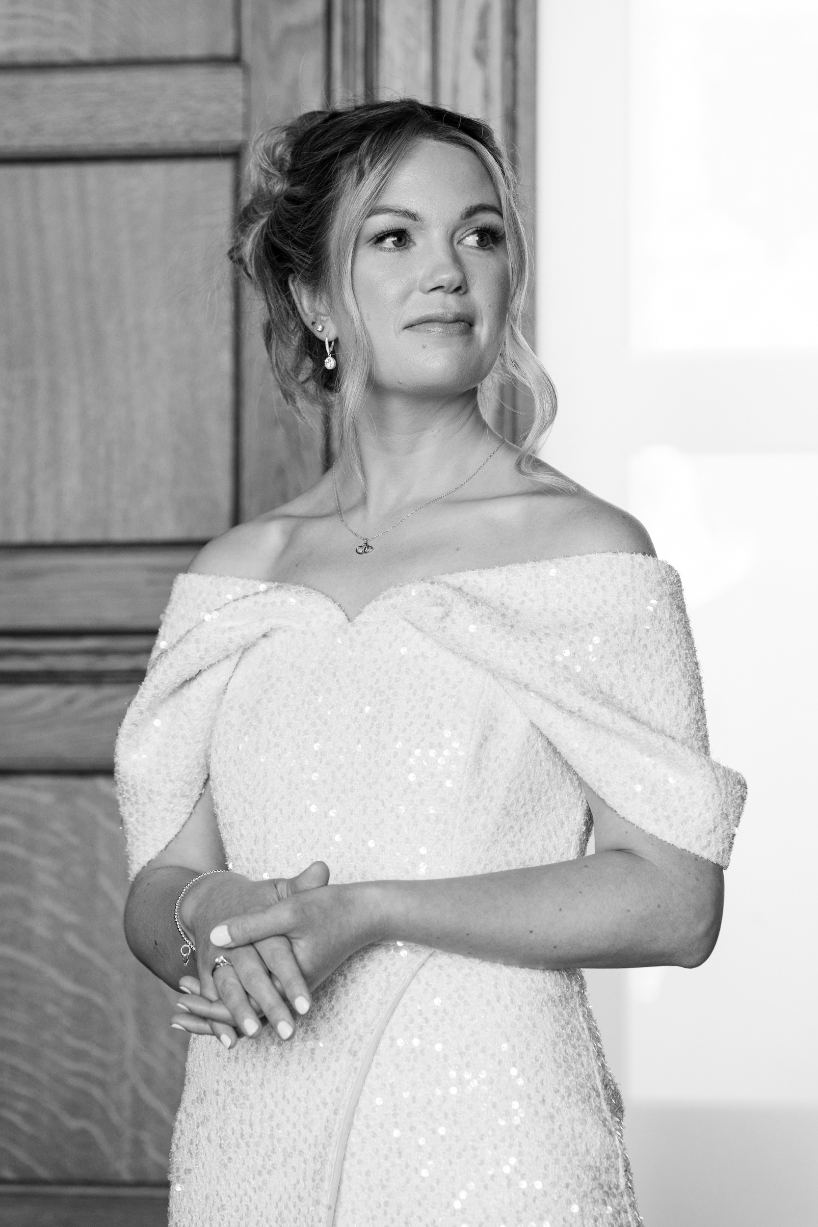 Black and white photo of a bride in a sequin, off-shoulder dress.