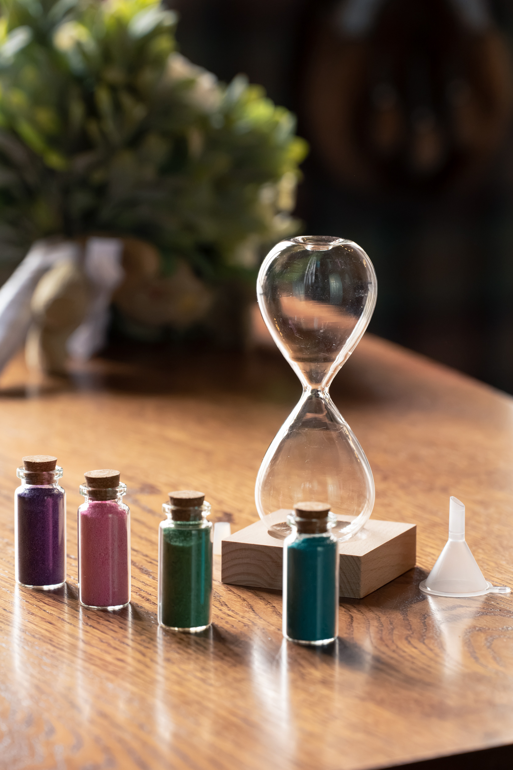 Wedding sand ceremony: An empty hour glass and vials of coloured sands.
